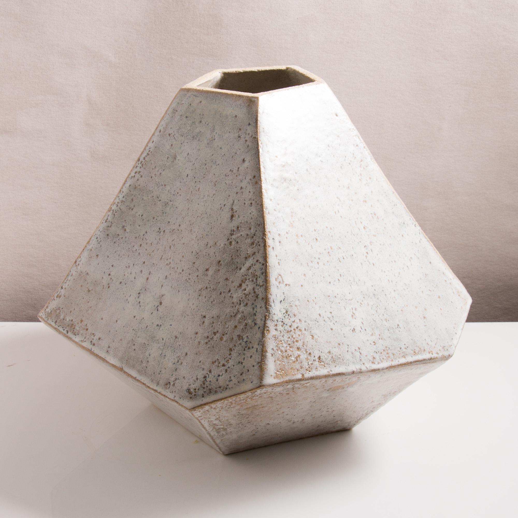 This large one-of-a-kind ceramic vase combines complex geometric lines with the warmth and individuality inherent in handmade work. It was assembled from flat sheets of a sandy stoneware, into a geometric shape that feels both natural and entirely