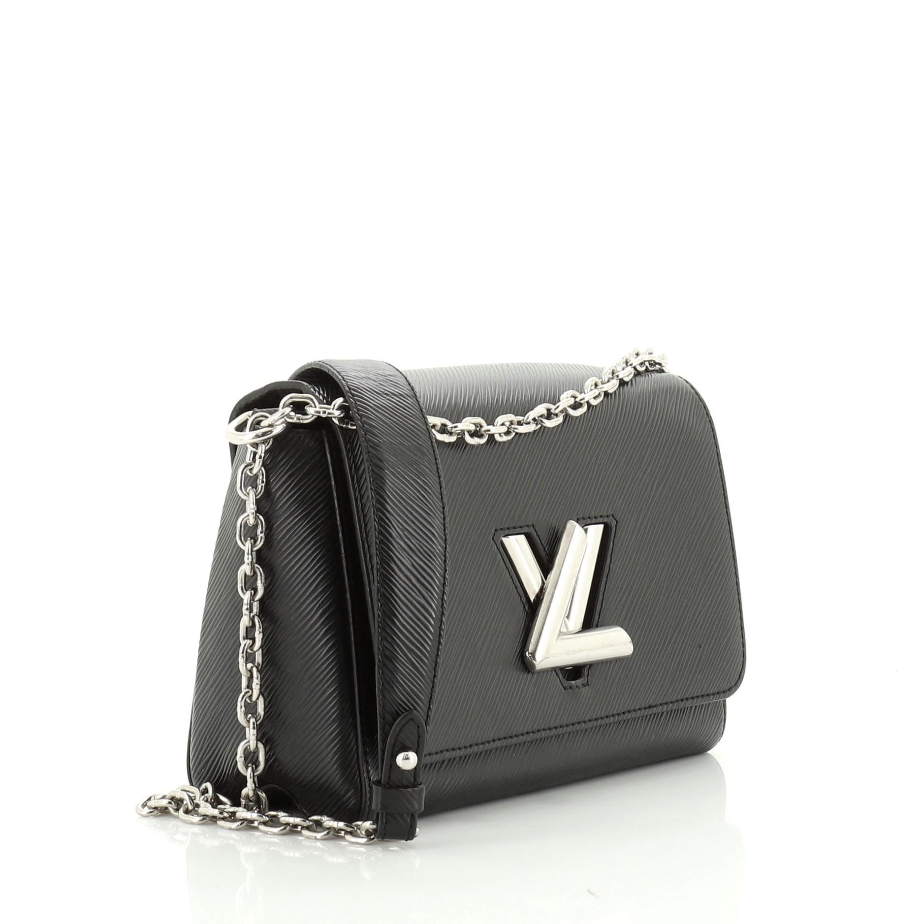 This Louis Vuitton Twist Handbag Epi Leather MM, crafted from black epi leather, features chain link strap with leather pad, frontal flap, and silver-tone hardware. Its LV twist lock closure opens to a black microfiber interior with slip pockets.