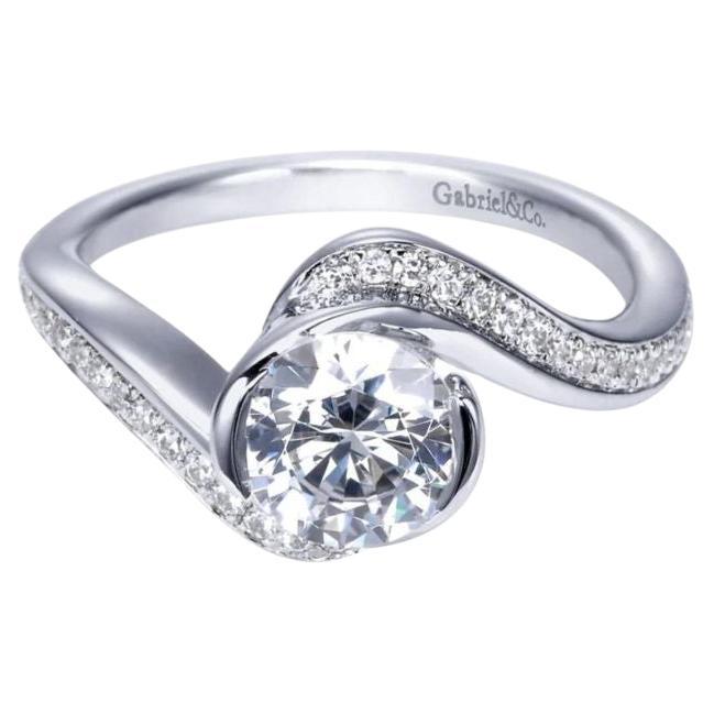 Ladies' Twisted 14k White Gold Diamond Engagement Mounting. Elegant bypass gently embraces the center stone in a semi bezel to add a contemporary touch to the ring. Center diamond NOT included. Side diamonds are 0.19 ctw, H color, SI clarity.