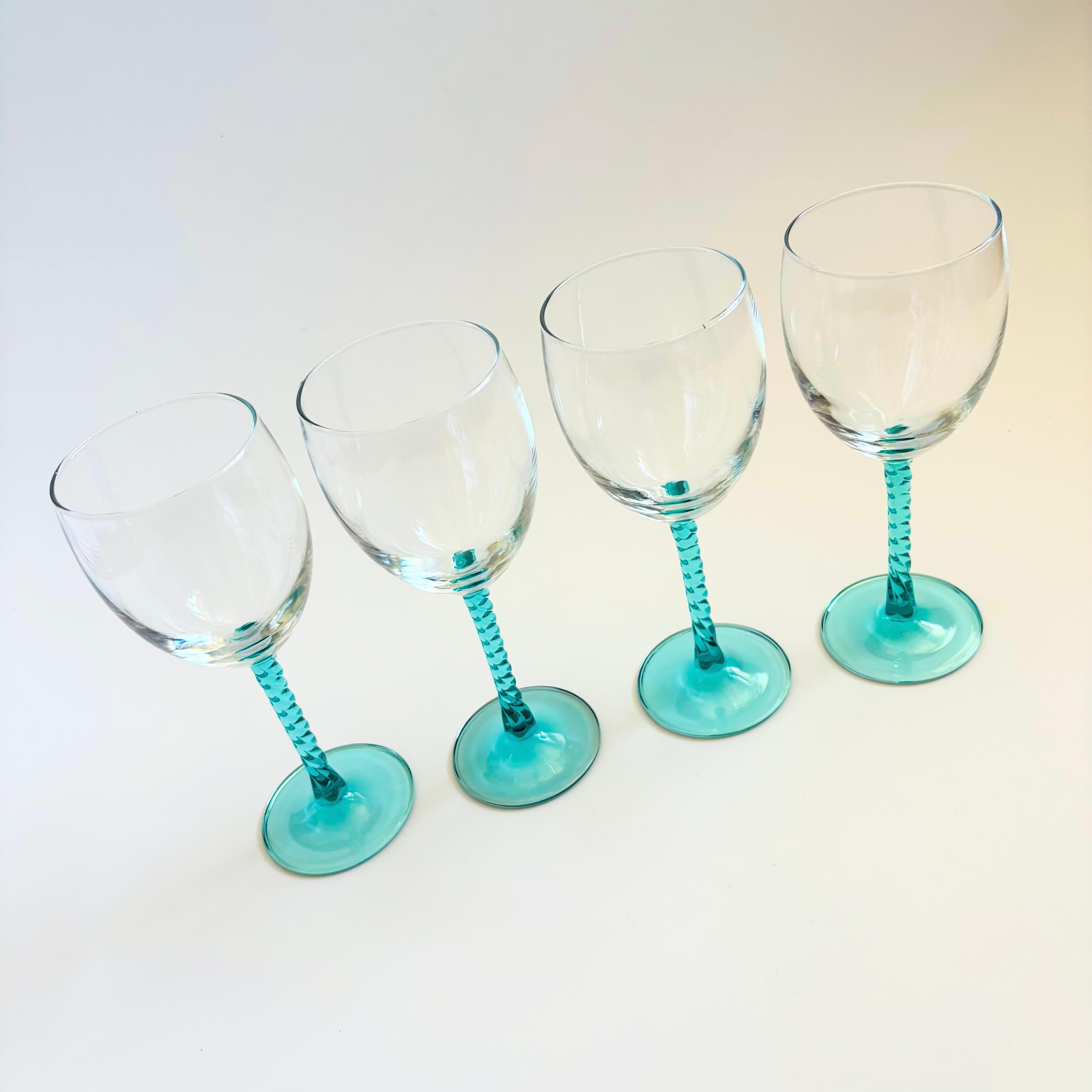 A set of 4 vintage wine glasses. Each with a twisted stem in aqua colored glass. Clear tops. Made in the 
