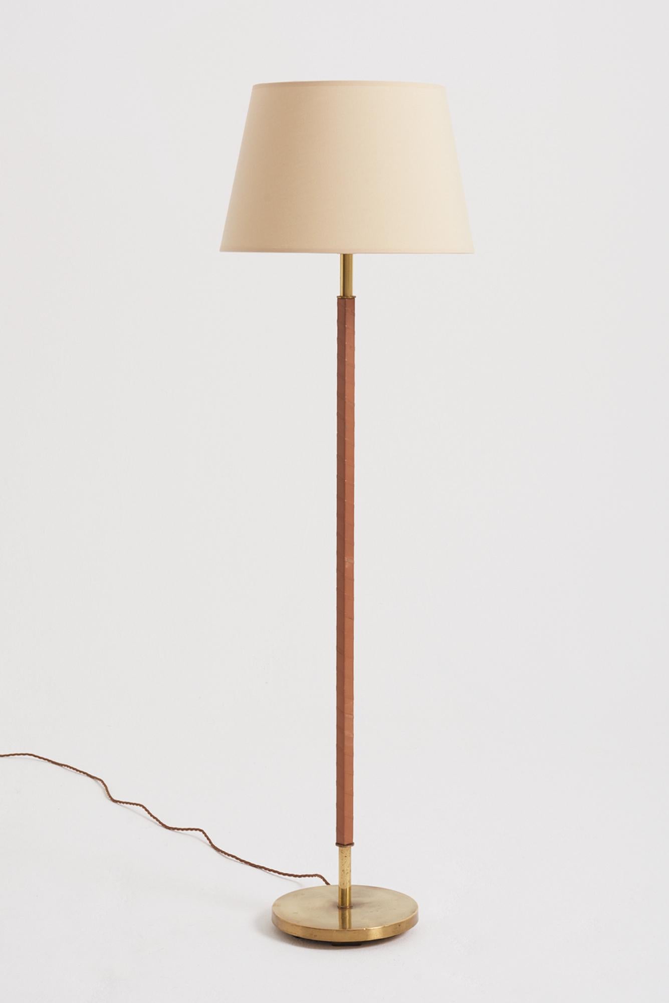 A brass and twisted faux tan brown leather floor lamp.
Sweden, third quarter of the 20th Century
With the shade: 139.5 cm high by 41 cm diameter
Lamp base only: 120 cm high by 24.5 cm diameter
