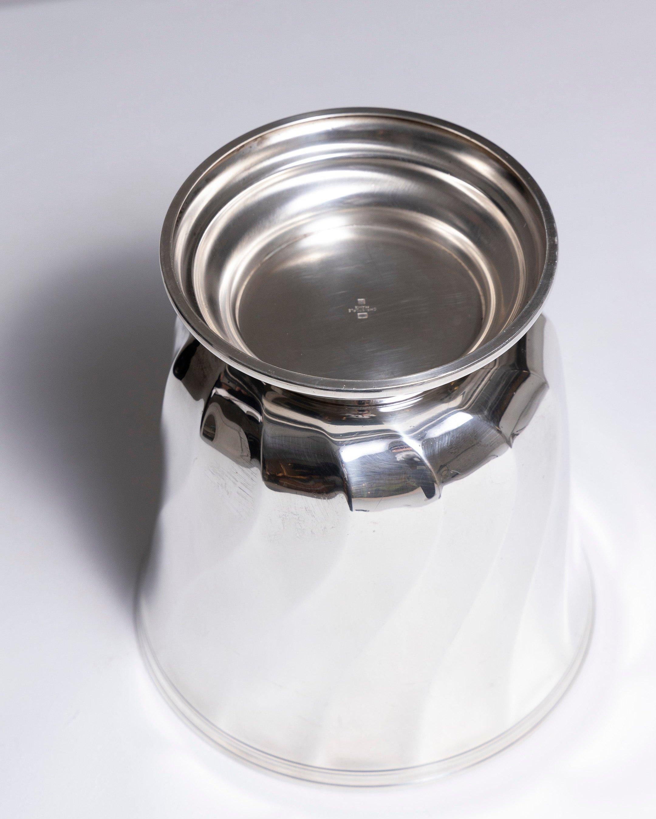 Champagnerkübel aus versilbertem Metall von der französischen Silberschmiede Christofle, 1980er Jahre. Mit einem gedrehten Reliefmuster, das auf der Unterseite gestempelt ist. Leichte Oberflächenkratzer, insgesamt in gutem Zustand.
LP3844
