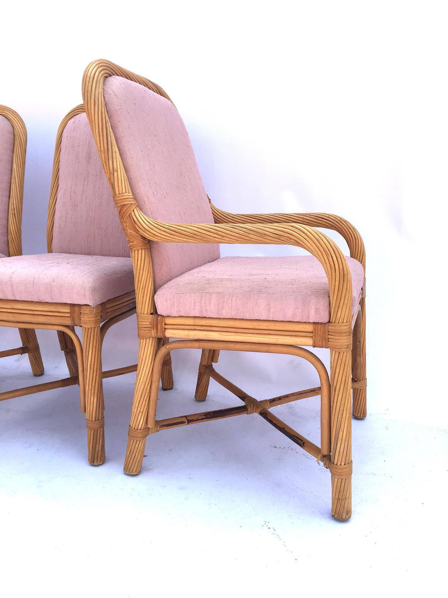 Set of six twisted rattan dining chairs, two armchairs and four standard. Bent rattan with muted pink upholstery. 

Good vintage condition with minor wear to upholstery. 

Armchairs measure 22.5 wide, 26 deep, and 39.5 tall. Seat measures 17.5