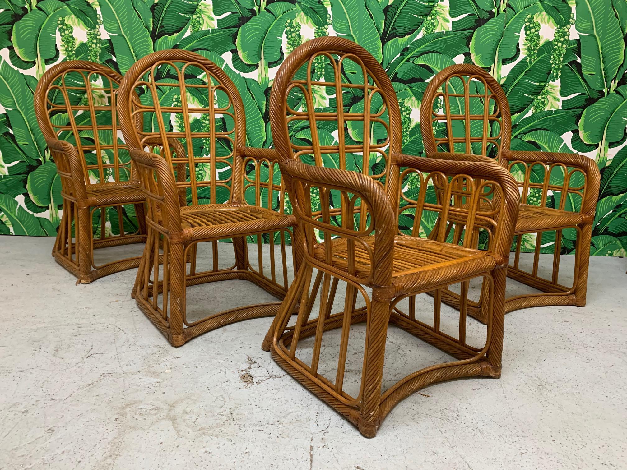 Set of four vintage dining chairs feature high backs and a twisted rattan design. Unique look with a skirted splayed base. Ready for your cushions to complete your decor. Good vintage condition with imperfections consistent with age (see
