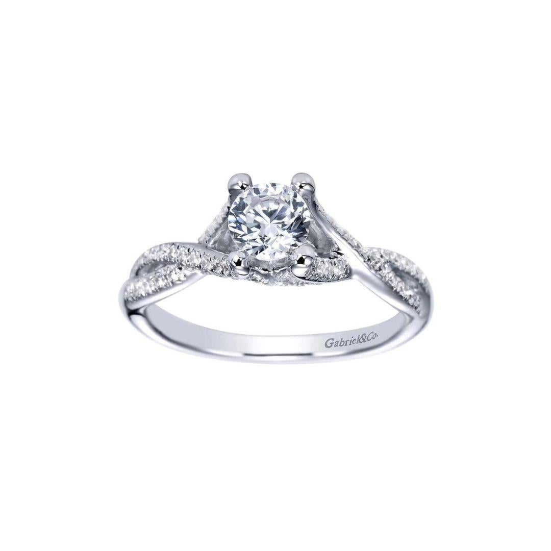 Diamond Halo Engagement Ring in 14k White Gold.﻿ Twisted design on the shoulders features pave studded braided shank, gracefully leading up to the center diamond. Center diamond weighs 0.50 ct, H color, SI1 clarity. Side diamonds are  0.625ctw, H