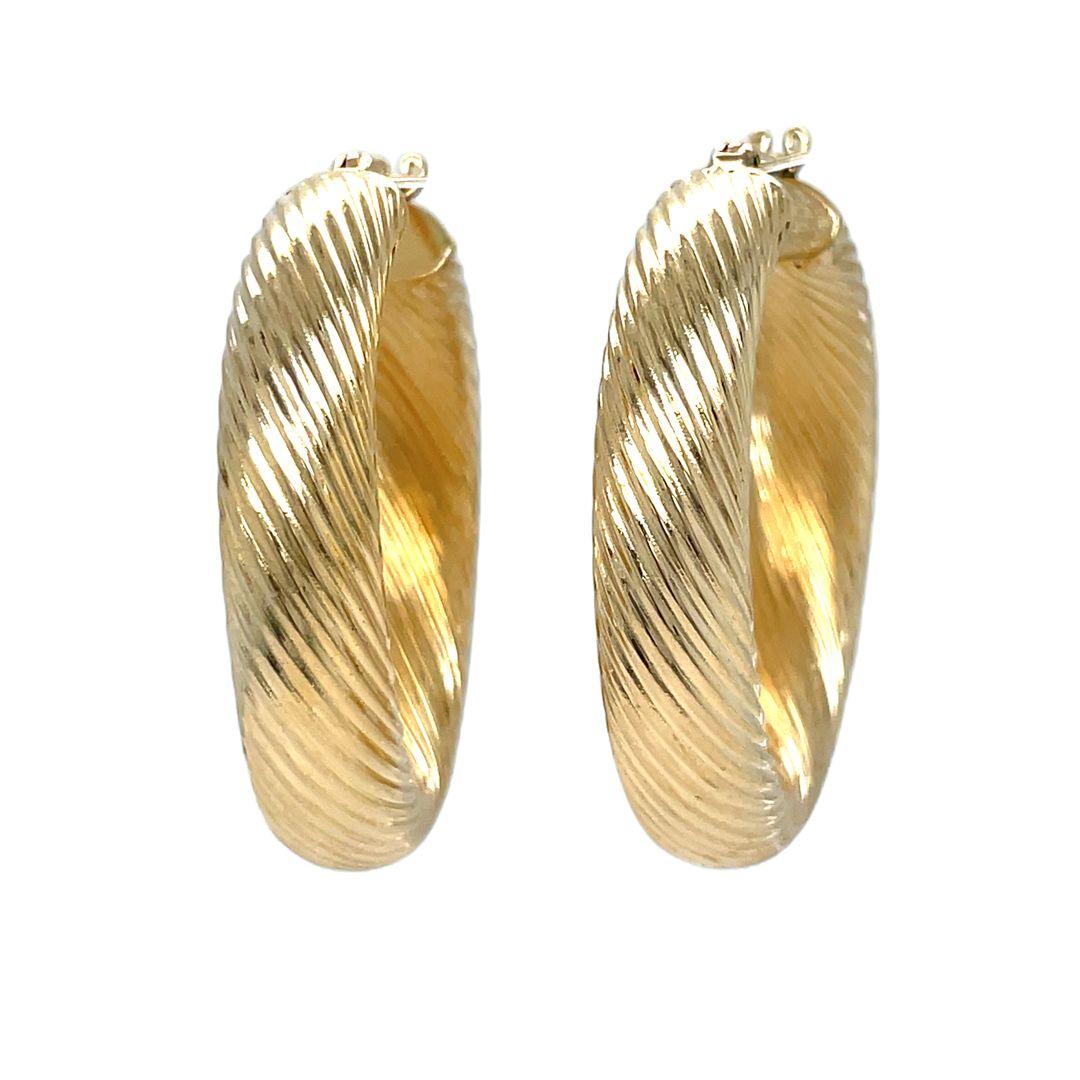 Make a bold statement with these twisted rope hoop earrings, beautifully crafted from 14k yellow gold. These timeless women's hoops showcase 35mm hollow round tubes, elegantly twisted and polished to a high shine. Secured in place with hinged backs,