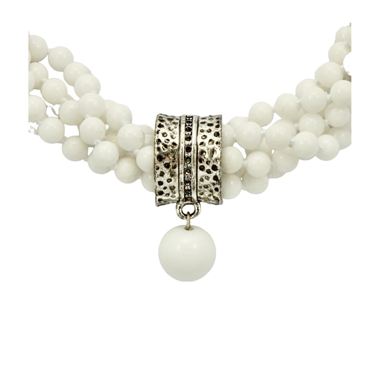 Wunderschöne fünfsträngige, gedrehte weiße Perlenkette mit einem versilberten und schwarz emaillierten Mittelstück. Die Perlen werden zwischen den einzelnen Perlen verknotet, und das Mittelstück ist frei beweglich auf der Halskette. Der Anhänger ist