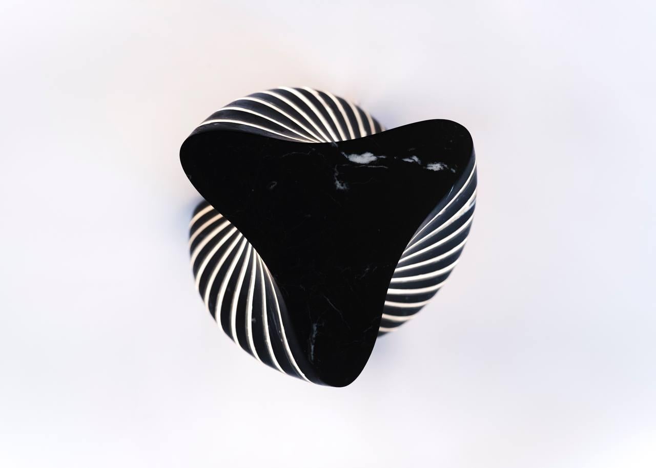 La Lámpara Twister es el arte de la luz y la forma.

Las líneas elegantes y fluidas del mármol negro Marquina se combinan con la ligereza del vidrio para crear una espectacular pieza de diseño interior. Sus dimensiones compactas (30 × 34 cm) hacen