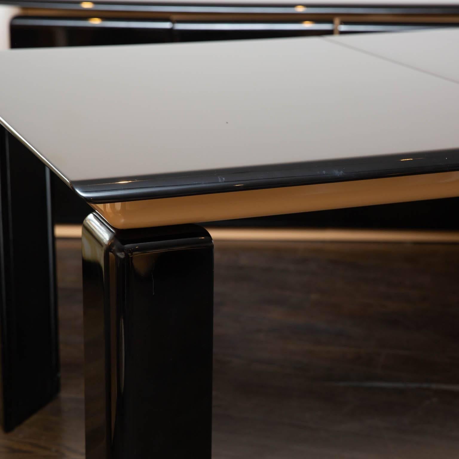 Clean black and tan lacquered dining table with angled legs. Made in Canada and designed by Roger Rougier. Does not come with leaves.