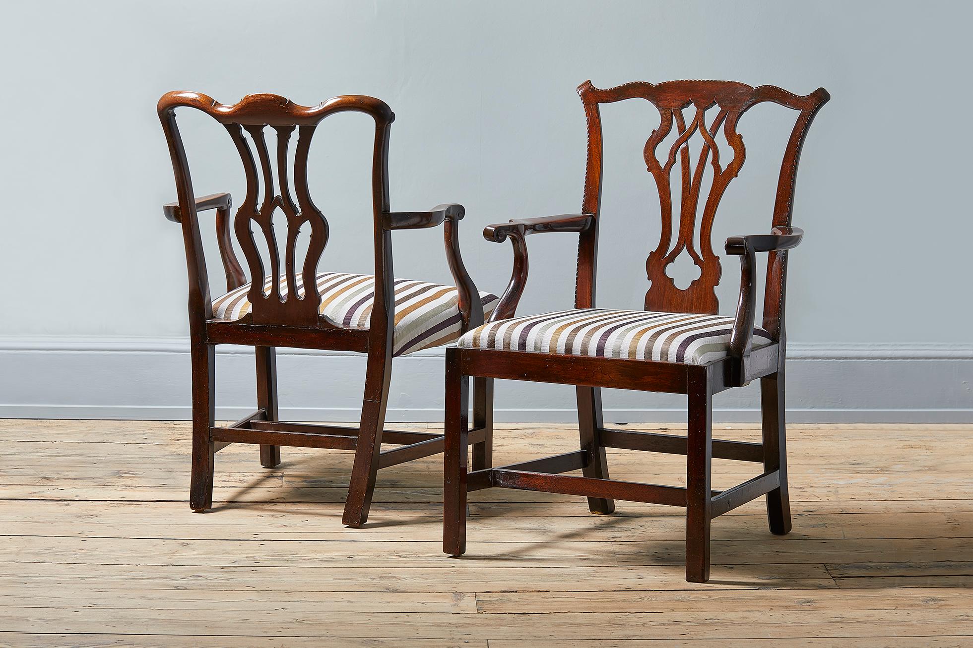 Two George II armchairs in the manner of Thomas Chippendale. Both dating from circa 1750, with mahogany frames, latticed splats and carved decor. The seats of both chairs recently reupholstered in Hermès ottoman fabric.