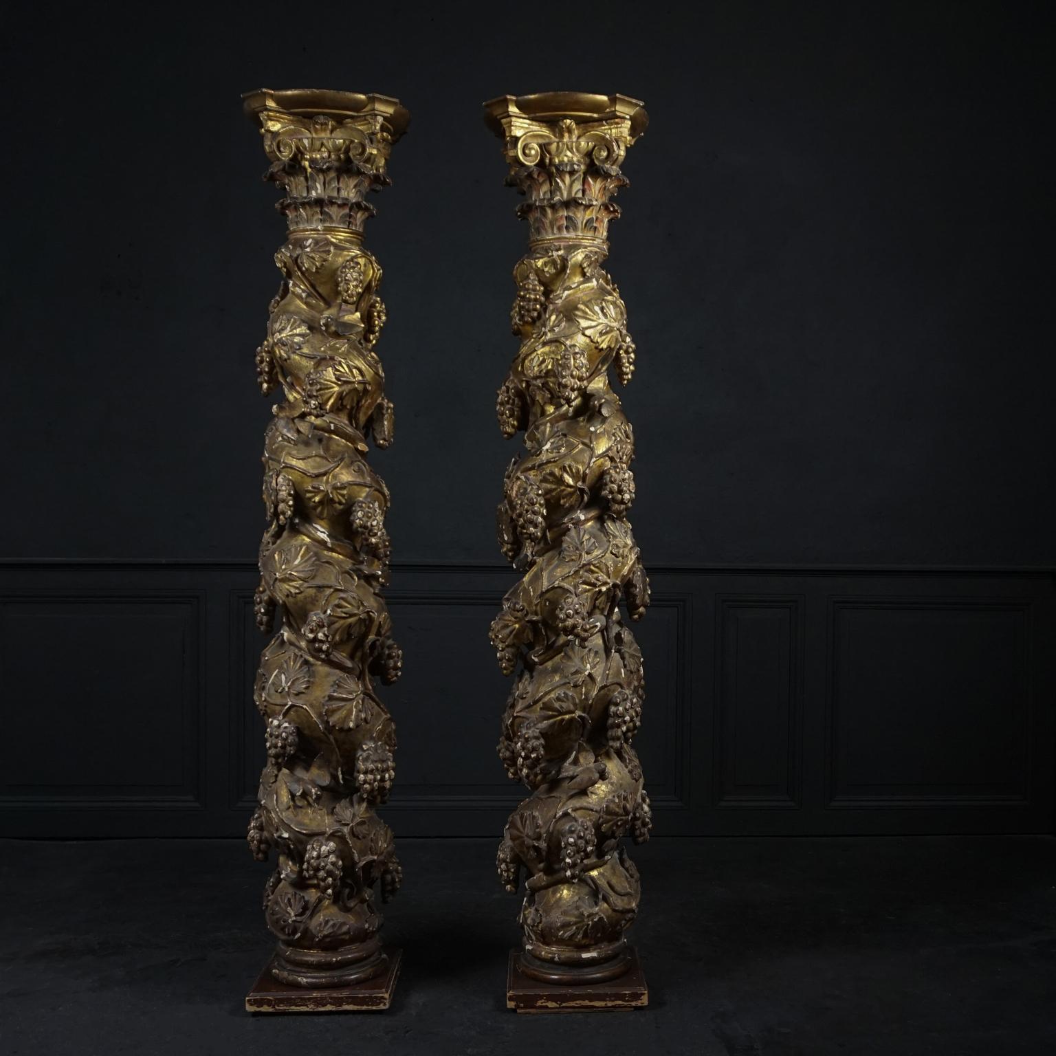 Exceptional pair of hand carved gilt swirled Solomonic columns.
With carved plastered polychromed and gilt relief decorations of three dimensional clusters of hanging grapes, grapevines and birds. Finished with Corinthian capitals on top. 

These