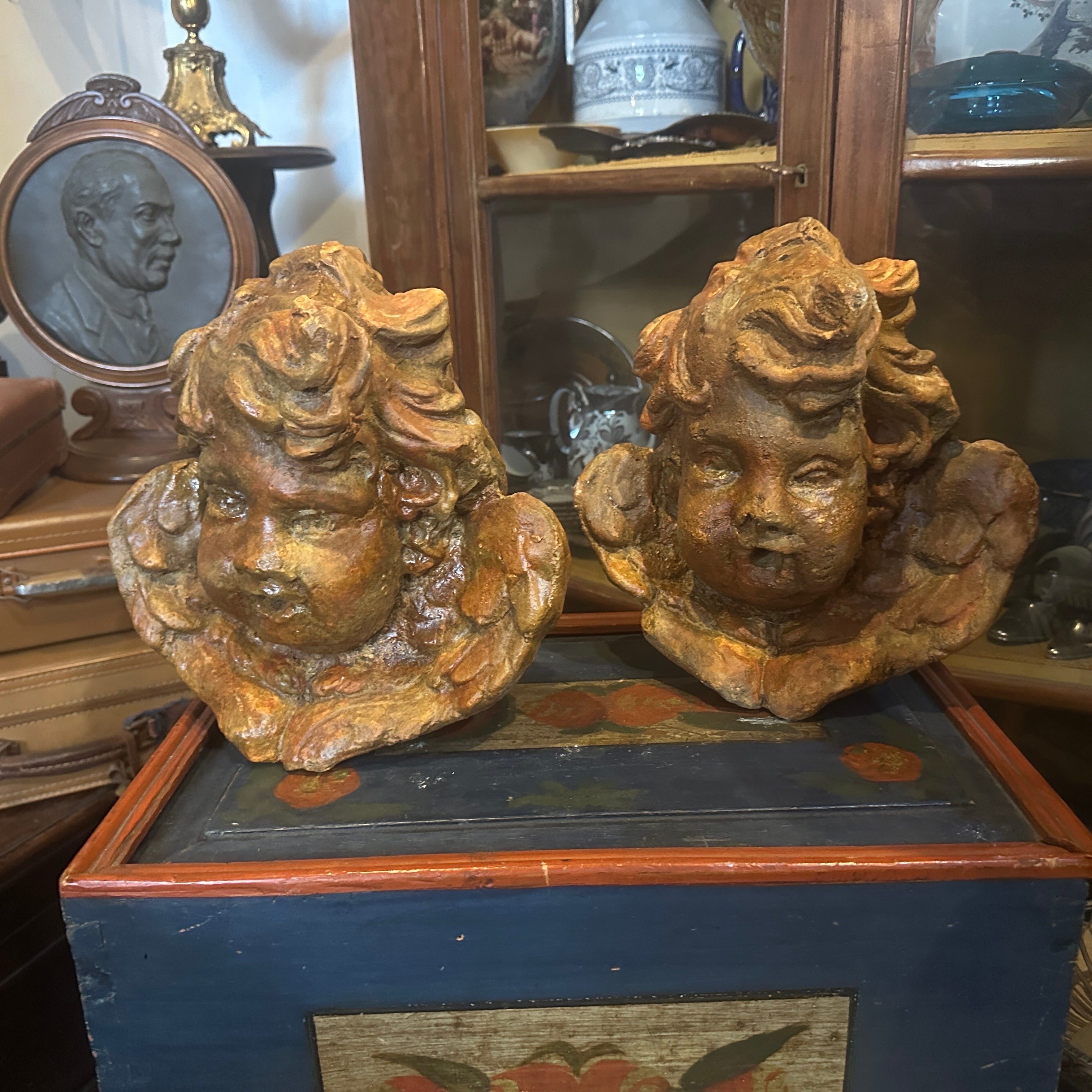 Two sculptures of angels heads in stone mixture made in 1930s in Sicily, they were used as decorations in a villa, they are in original conditions and patina with signs of use and age. The Angels are a pair of intricately crafted stone sculptures,