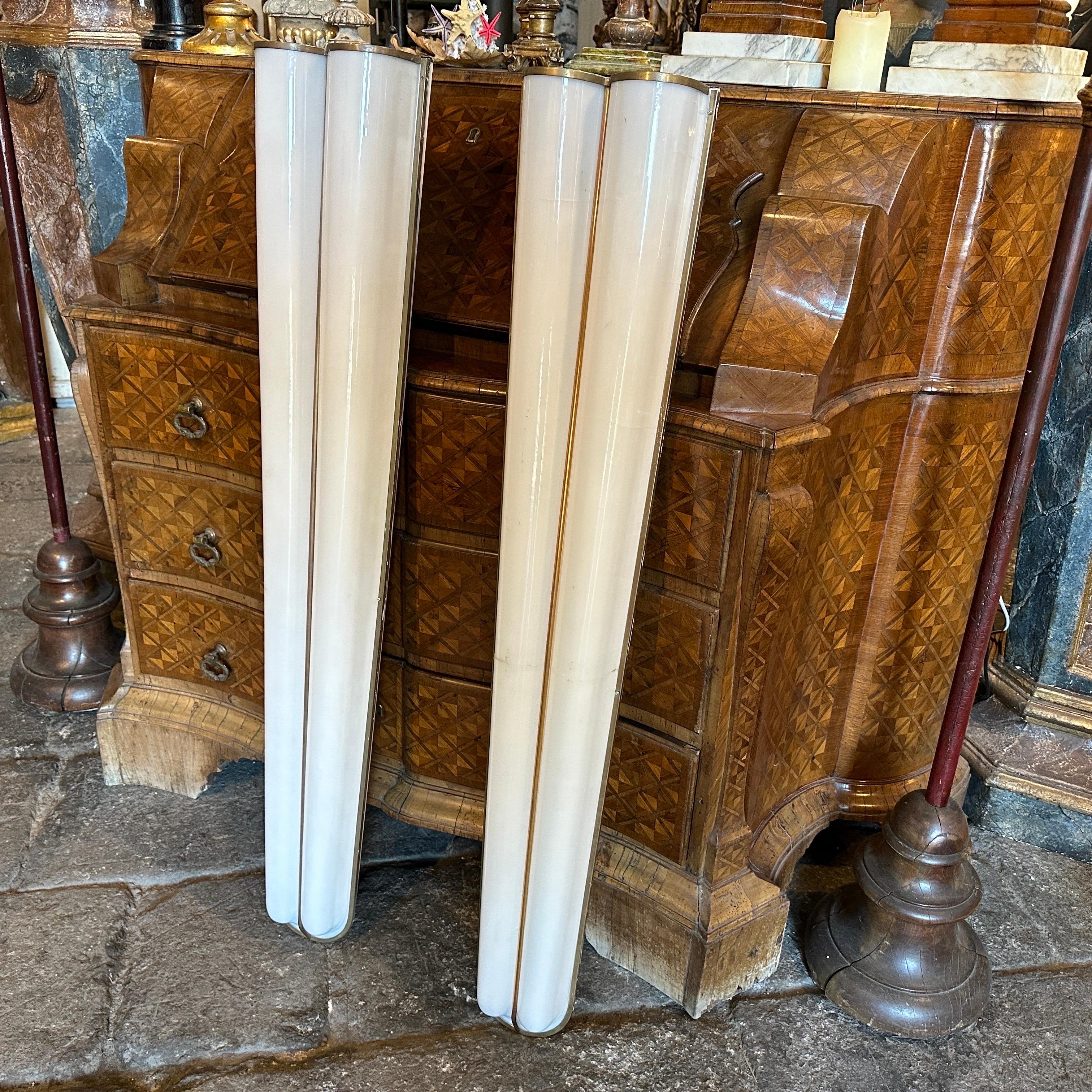Two big theater wall sconces designed and manufactured in Italy in the Fifties, both wall lights have a line in the plexiglass visible on the photos. They are in working order. The sconces feature brass as the primary material for their frames.