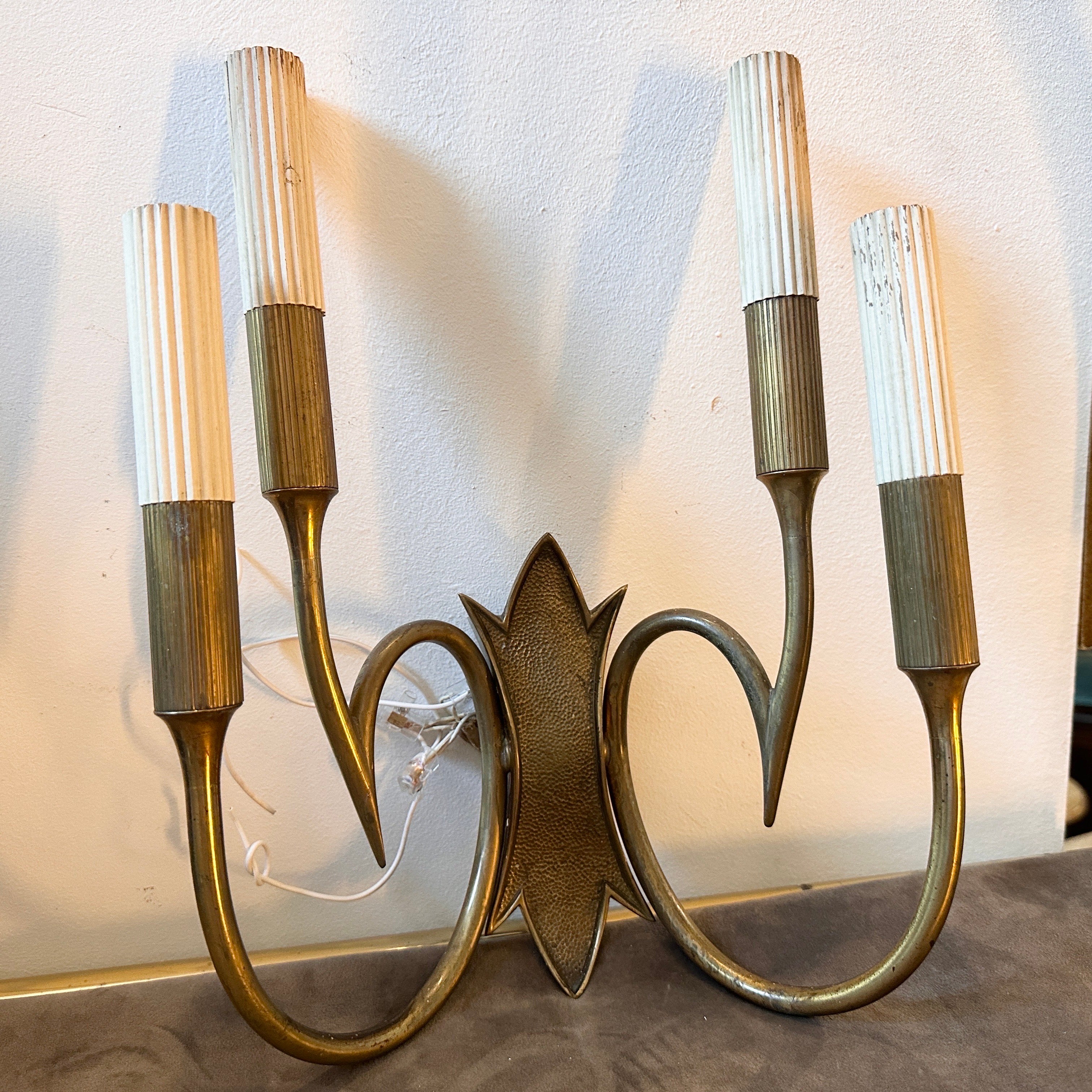 
These Two 1950s wall sconces designed and manufactured in Italy in the manner of Oscar Torlasco exude a timeless elegance and sophistication characteristic of the mid-century design era. Oscar Torlasco was a renowned Italian lighting designer known
