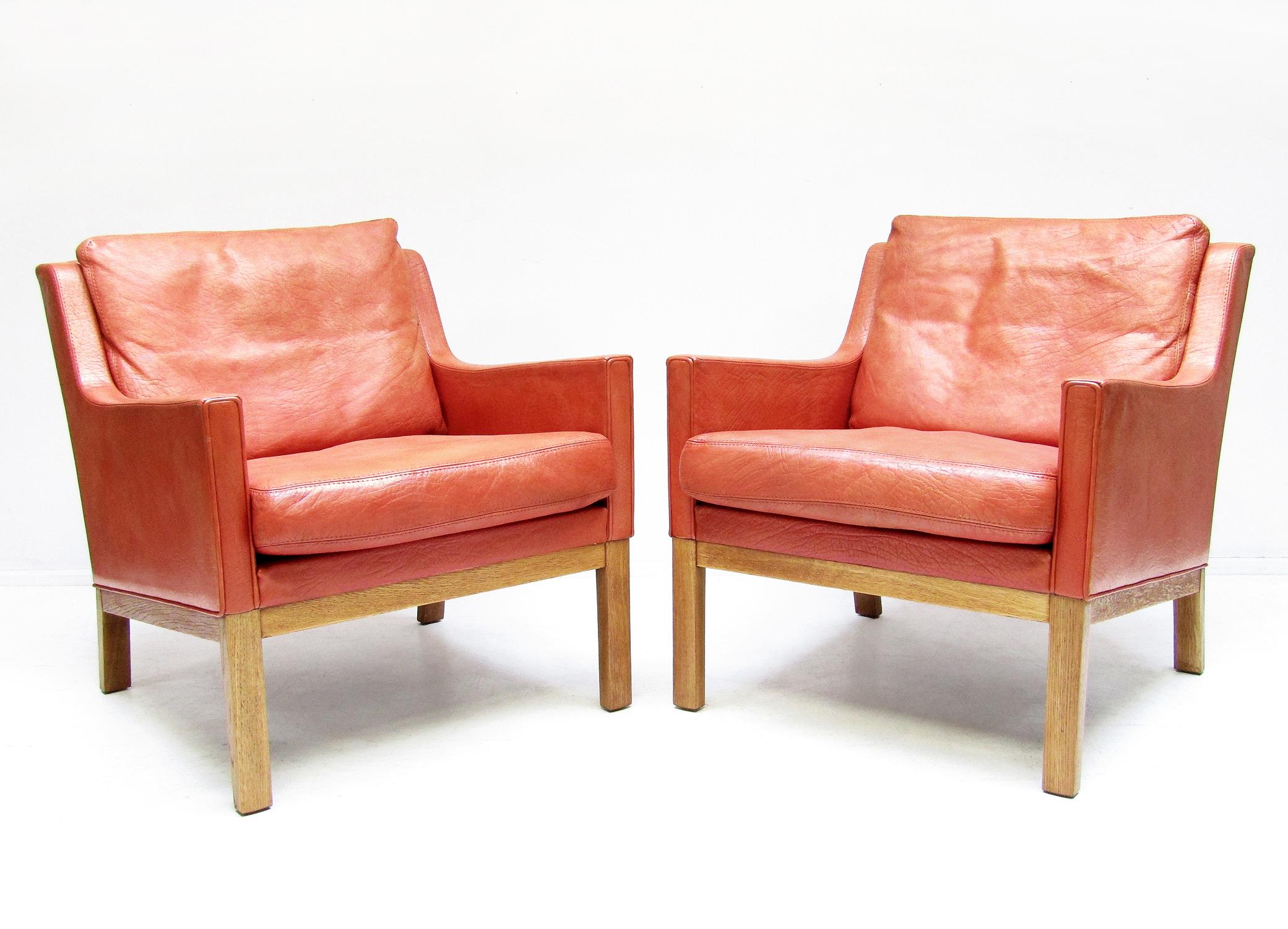 A pair of 1960s Danish lounge chairs by Kai Lyngfeldt Larsen for Søren Willadsen.

In lobster-red leather on a streamlined oak base they make a vibrant mid-century statement.

Similar to Borge Mogensen designs, the quality is typical of the