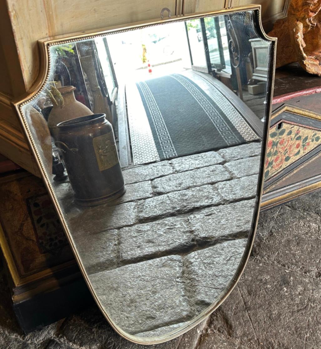 Cette paire exquise de miroirs muraux en laiton du milieu du siècle dernier incarne le langage sophistiqué de Gio Ponti, figure emblématique du design italien du XXe siècle. Ces miroirs sont un exemple remarquable de la capacité de Ponti à mélanger