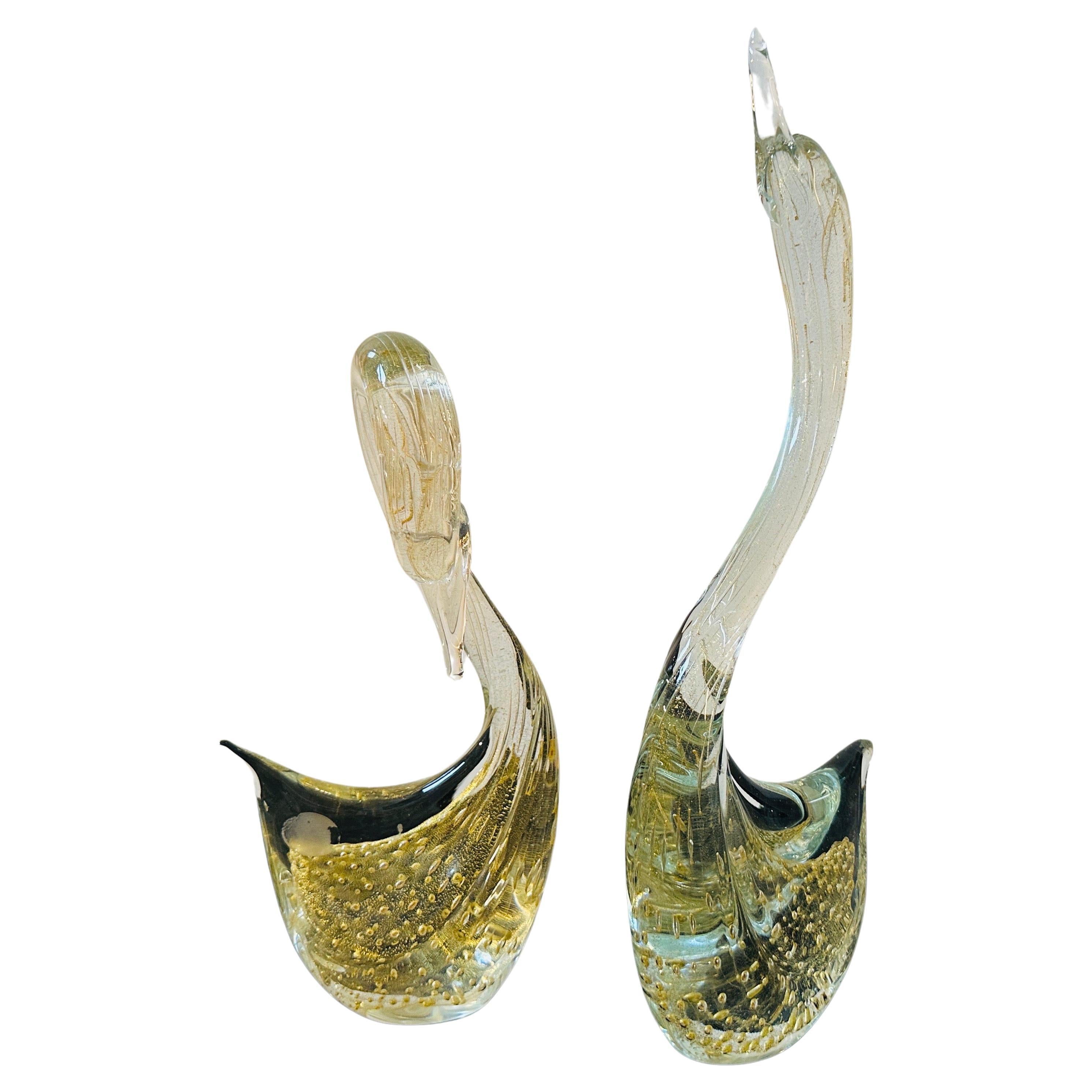 Two 1960s Modernist Clear and Gold Murano Glass Sculptures of Swans are a delightful representation of the artistry and craftsmanship associated with Murano glass. The swan sculptures embody the elegance and grace of these majestic birds through the