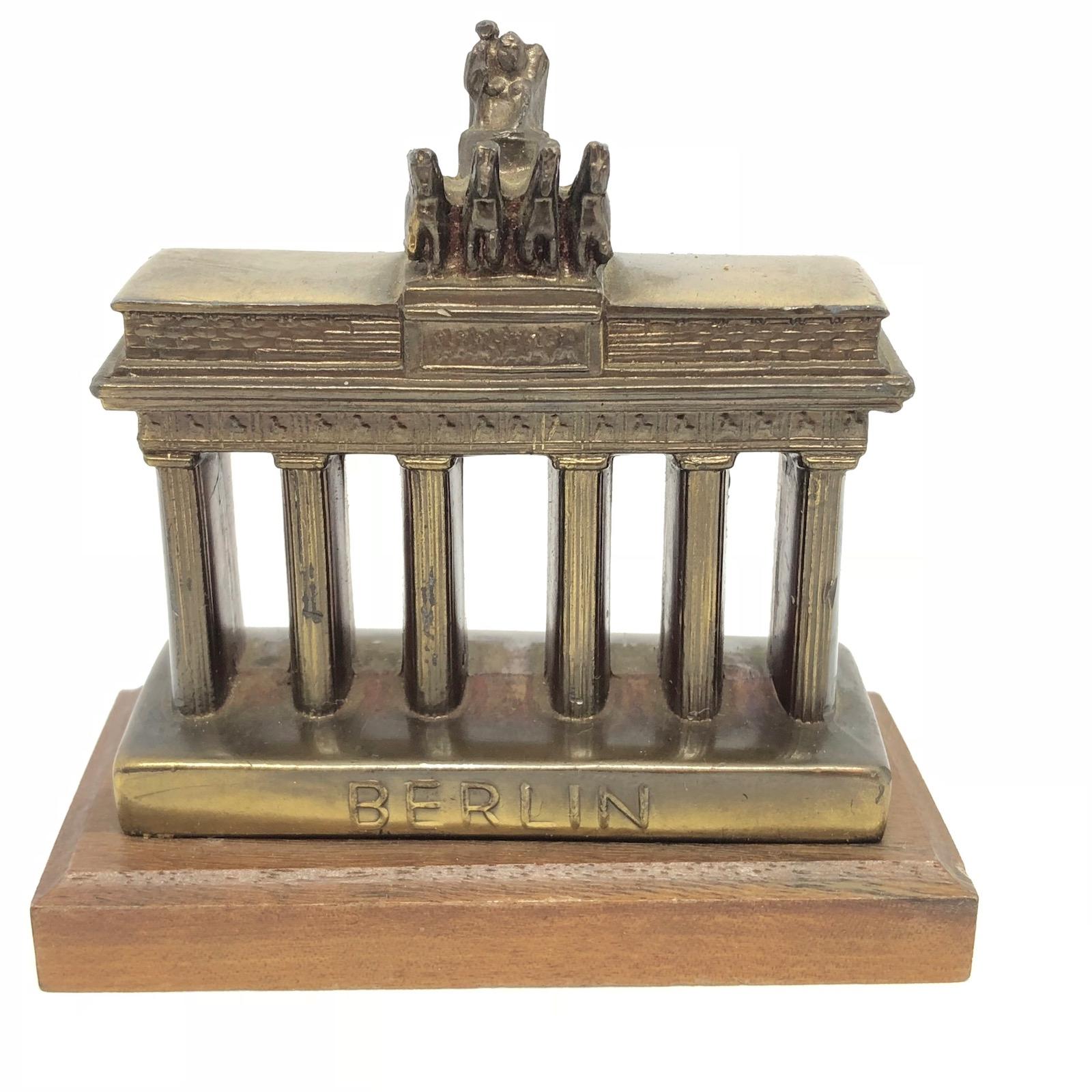 A decorative Brandenburg Gate souvenir building sculpture and a Berlin bear statue. Some wear with a nice patina, but this is old-age. Made of metal and a wooden base. These items were bought as a souvenir in Berlin and were made in the mid-20th
