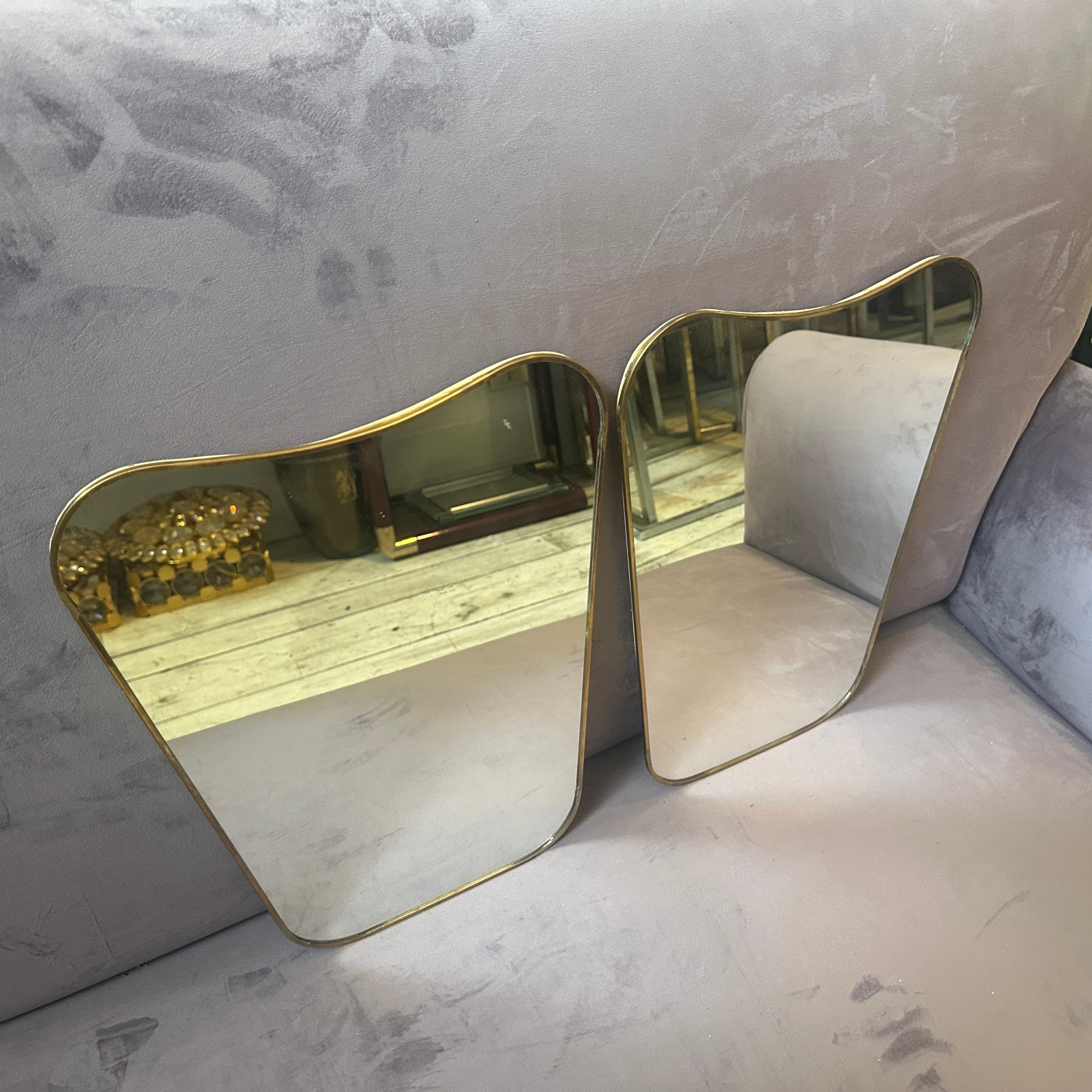 Un exquisito par de espejos de pared de latón estilo Gio Ponti moderno de mediados de siglo de la década de 1970 que encapsulan a la perfección la elegancia y el diseño sofisticado de la época italiana de mediados de siglo. Estos impresionantes