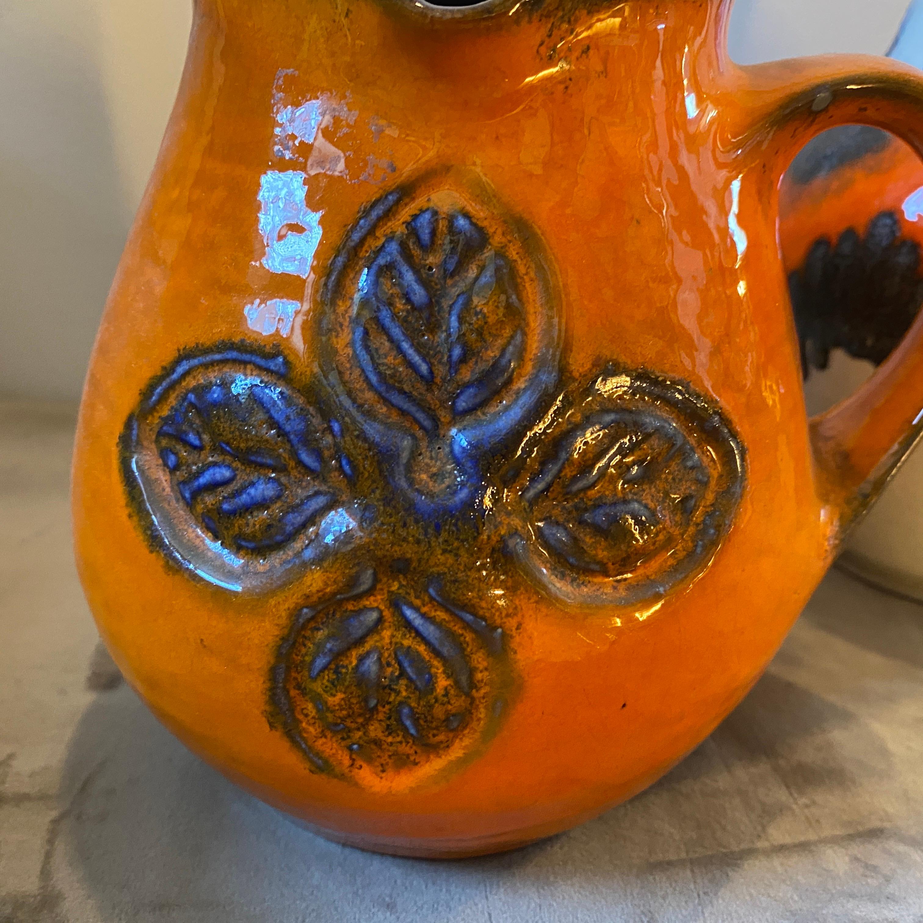 Two fat lava ceramic jug hand-crafted in Germany in the seventies. They are in lovely conditions, height dimension of the small one is cm 17. The orange color is an iconic color of the fat lava ceramic production. These German Jugs are iconic