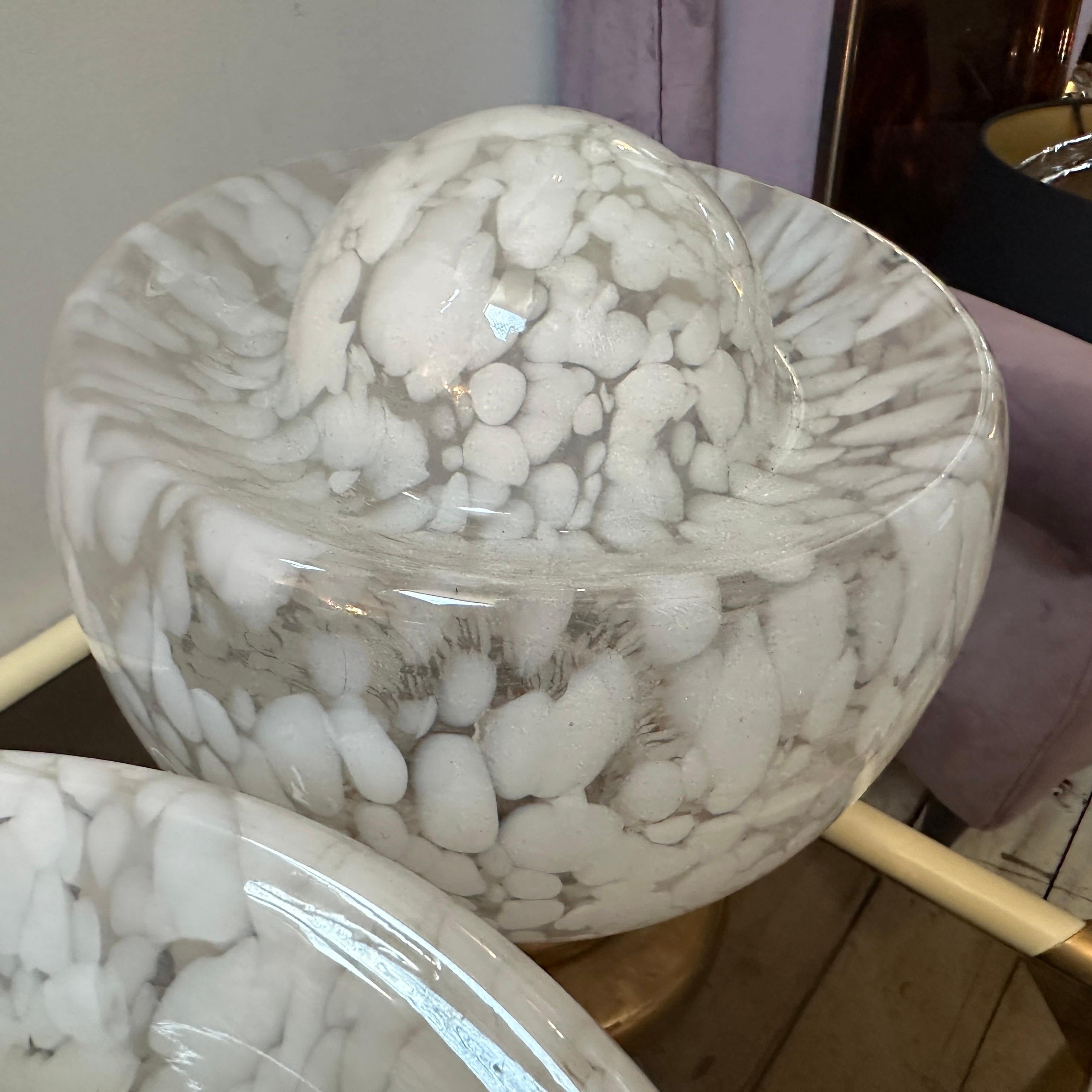 This is a pair of vintage 1970s clear and white Murano glass and brass table lamps designed by Nason for Mazzega. These lamps showcase Nason's signature style, combining organic forms with a modern aesthetic. The lamps feature large, hand-blown