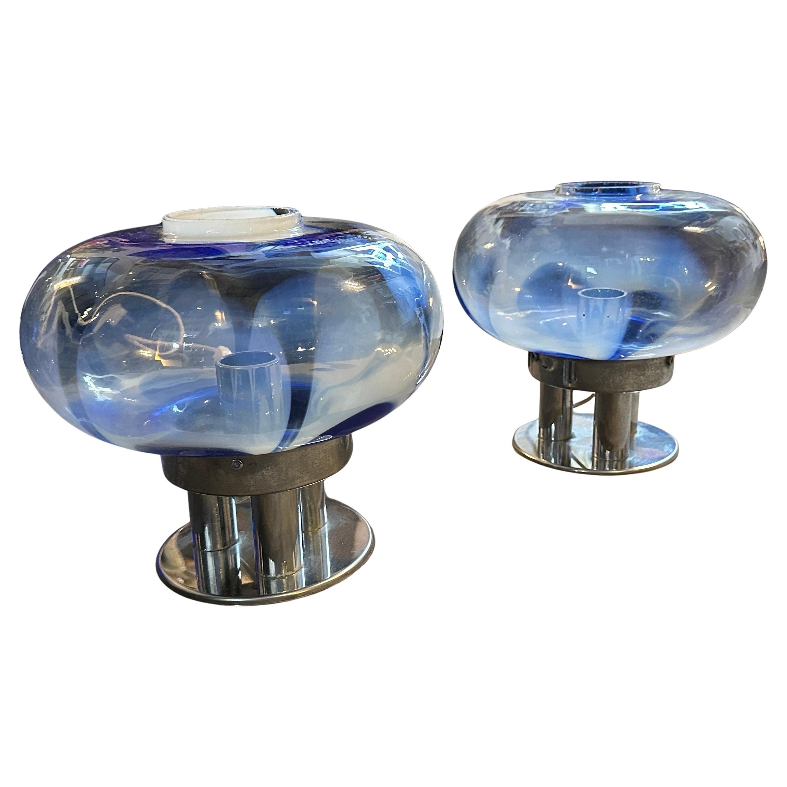 Verleihen Sie Ihrem Raum einen Hauch von retro-futuristischer Eleganz mit diesem Paar 1970er Space Age Tischlampen von Mazzega. Diese in Murano, Italien, fachmännisch gefertigten Lampen verfügen über atemberaubende mundgeblasene Glasschirme in einer