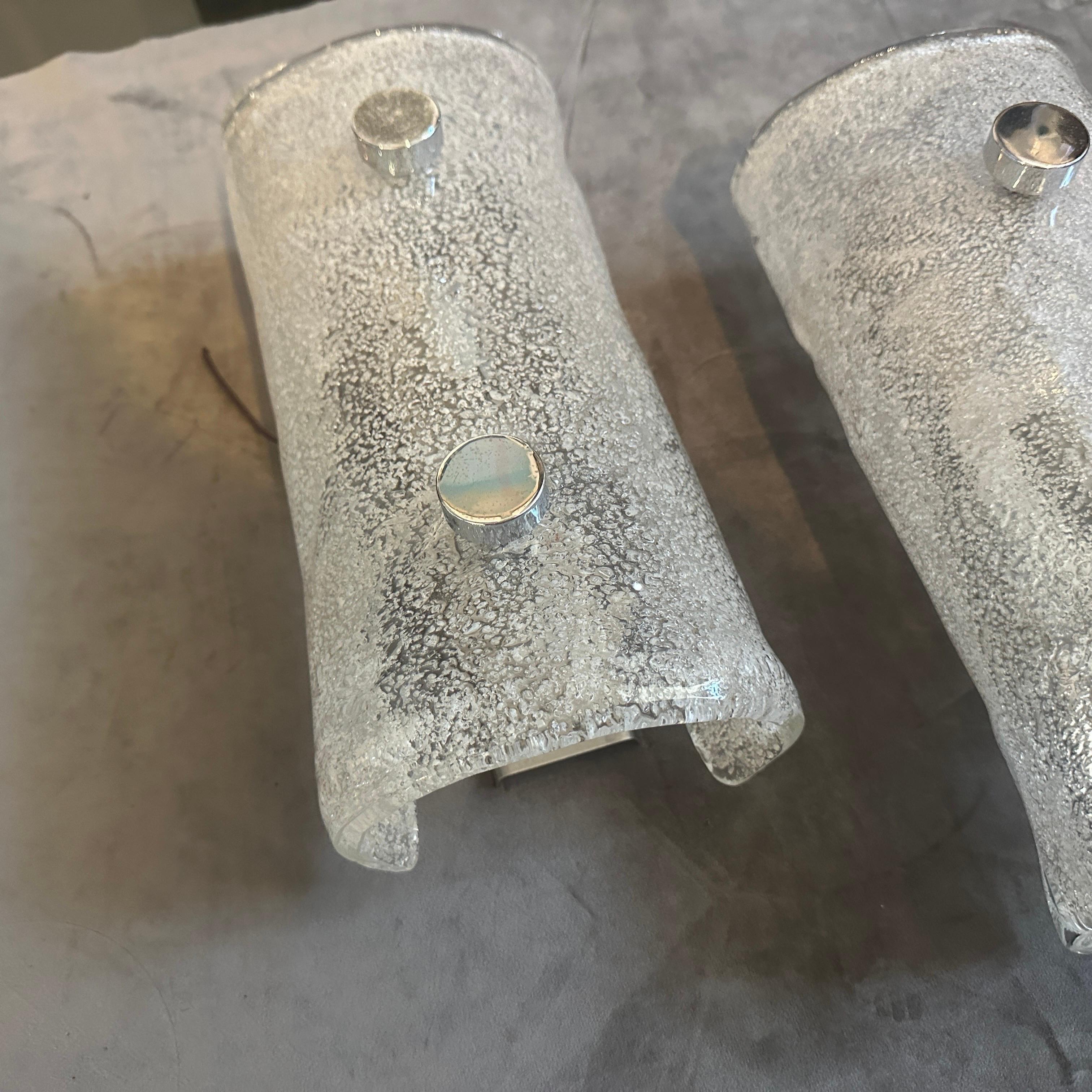 Este impresionante par de apliques de pared italianos vintage encapsula maravillosamente el movimiento de diseño de la Era Espacial de la década de 1970. Cada aplique tiene una pantalla semicilíndrica de cristal de Murano grueso y curvado. El propio