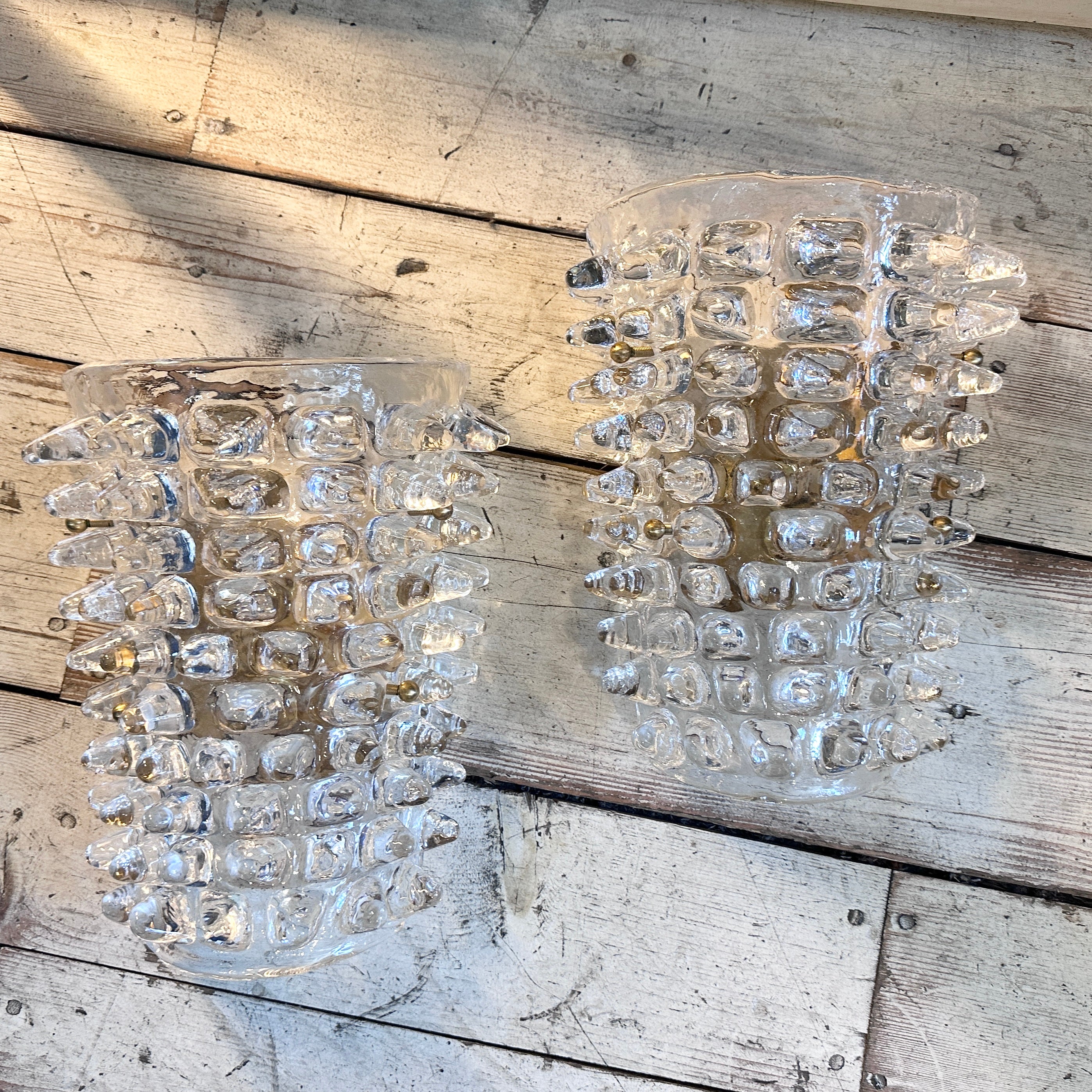 A pair of Mid-Century Modern rostrato transparent murano glass wall sconces hand-crafted in Italy in the style of famous manufacturer Barovier that invented this particular glass processing characterized by large light-reflecting points, obtained