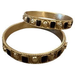 Two 1990s Iconic Gold Plated Metal and Black Enamel Bangle Bracelets by Chanel