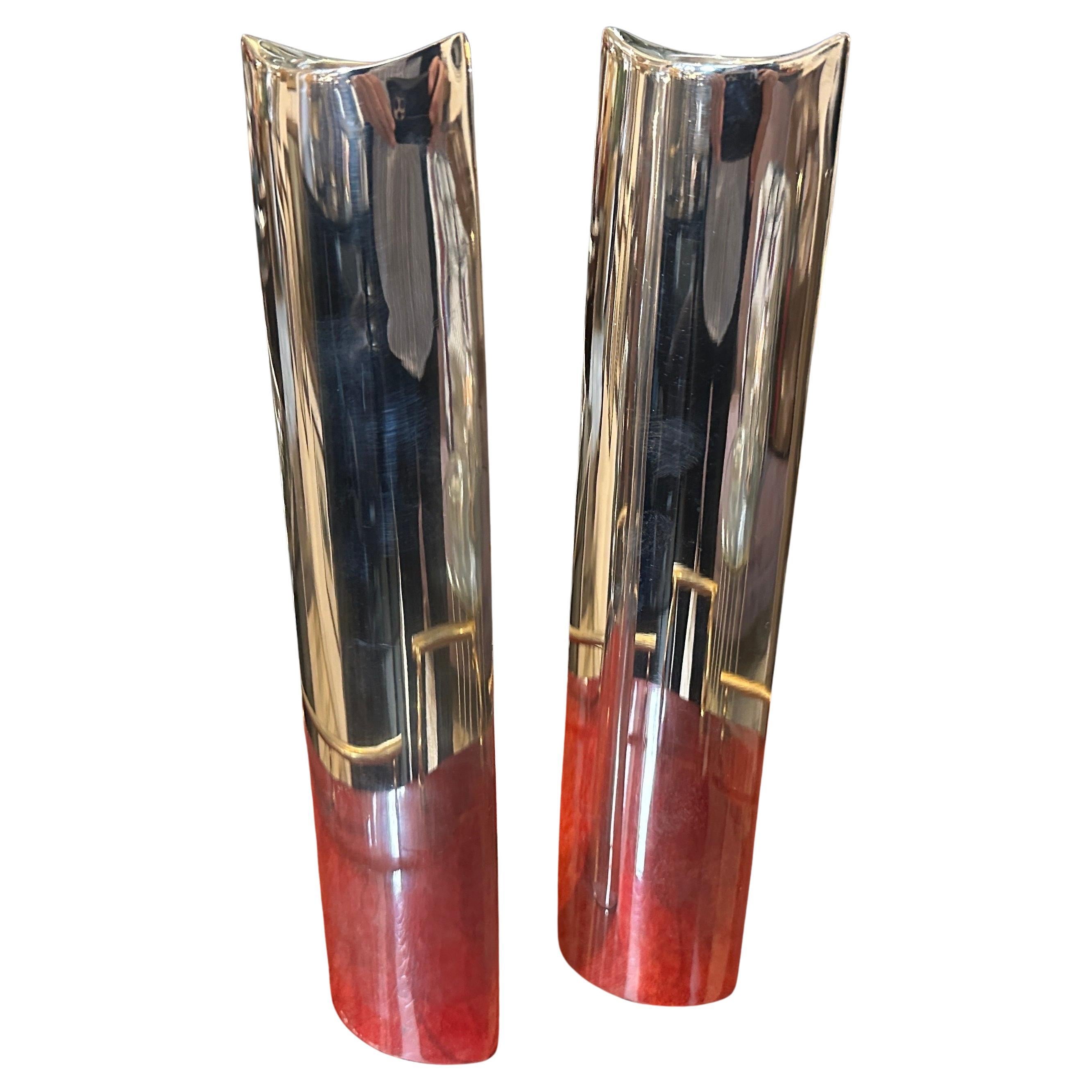 These two 1980s candlesticks, designed in the style of Lino Sabattini are striking examples of minimalist elegance. Their tall, slender form is crafted from silver-plated metal with a high-polish finish, reflecting light beautifully and adding a