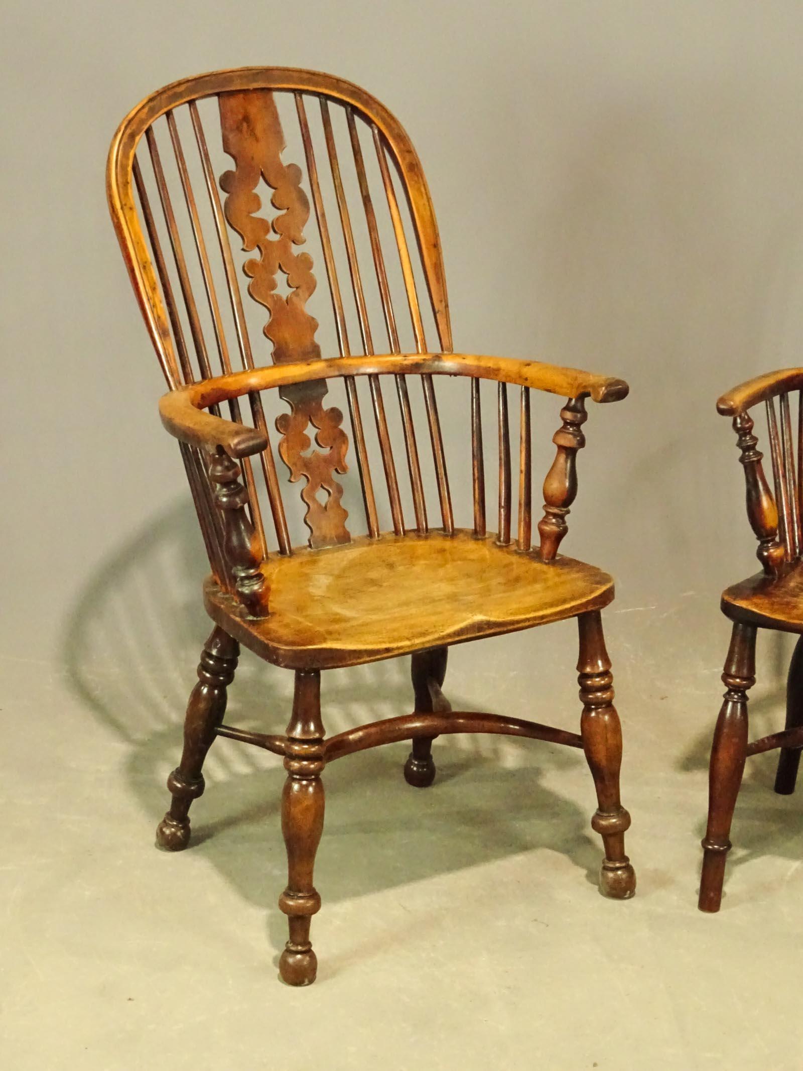 Two complementary antique English Windsor dining armchairs with wonderful aged wood patina. Chairs are hand carved with crinoline stretcher, body of the chair is beautifully figured yew, the seat is a single slab. Sold individually.
Chair on left