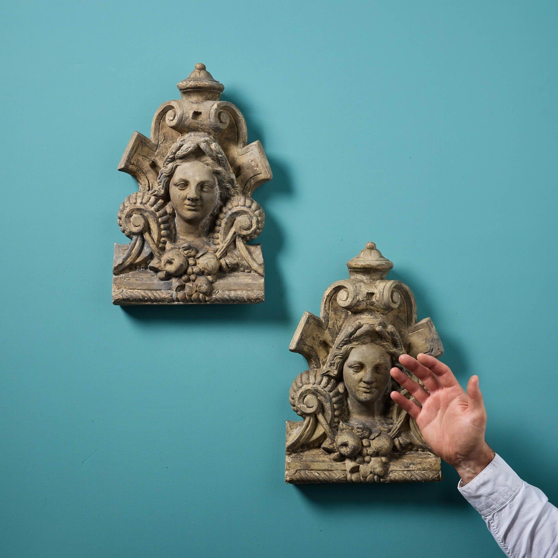 Diese beiden kunstvollen Wandbehänge aus polierter Terrakotta aus dem 19. Jahrhundert stellen entweder Demeter oder Ceres, die Göttin der Ernte, dar.

Die weiblichen Mittelstücke sind von Früchten und Schriftrollen umgeben. Jede von ihnen hat Körner