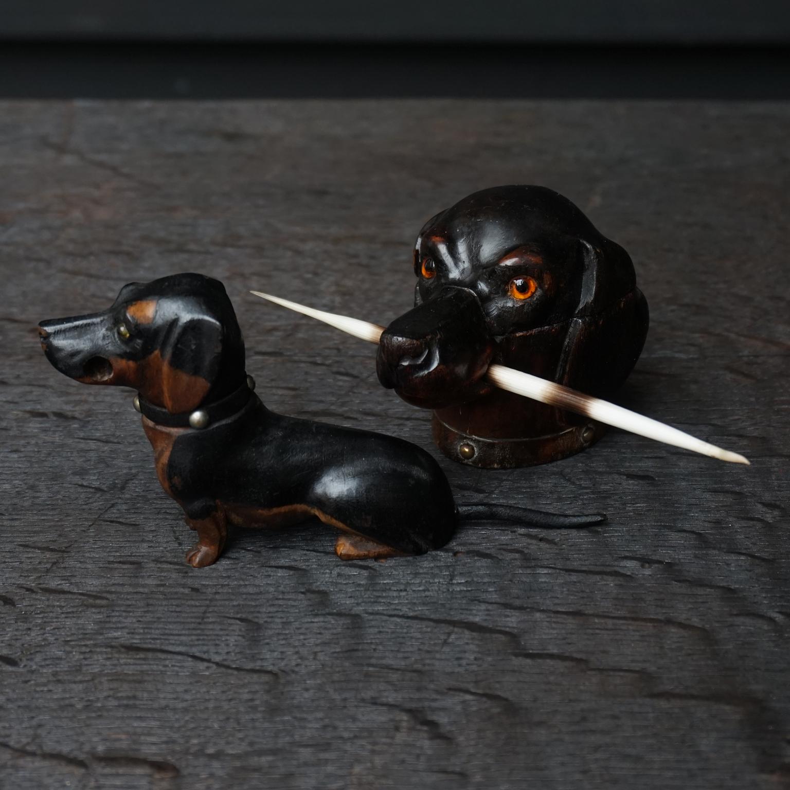 Set of two very cute original 19th century carved wooden Victorian era wiener dogs or dachshund inkwells.

The bigger one, which is a dachshund head, has a hinged lid that opens to reveal the little glass inkwell inside.
He has a nice carved collar