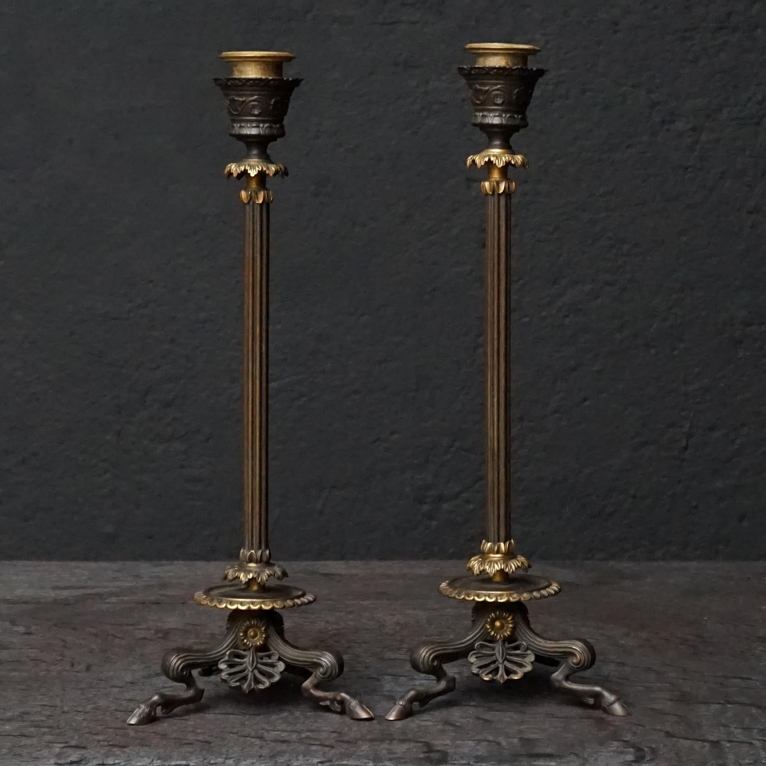 Two 19th century French partially ormolu bronze candlesticks on cloven hoofed hocked faun legs and feet

Cast in bronze, adorned with floral and acanthus leaf motif. 
The candle inserts and floral decorations are fire gilt, ormolu.
As you can see