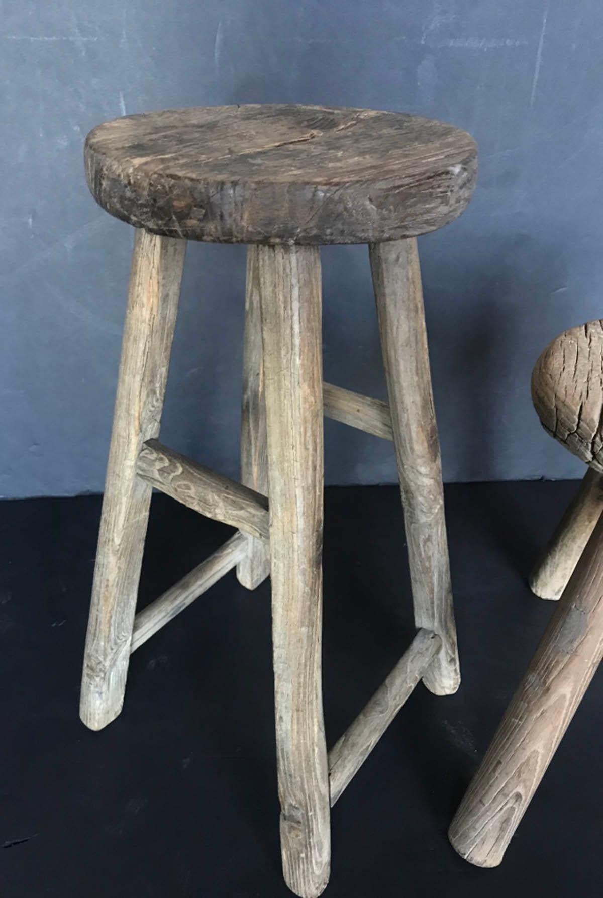 Rustic 19th century Elm stool from China with different stretcher configuration. These are sold separately. The left measures 9 inches diameter on the seat. The footprint is 10.5 by 11 inches and the overall height is 20.75 inches. Structurally