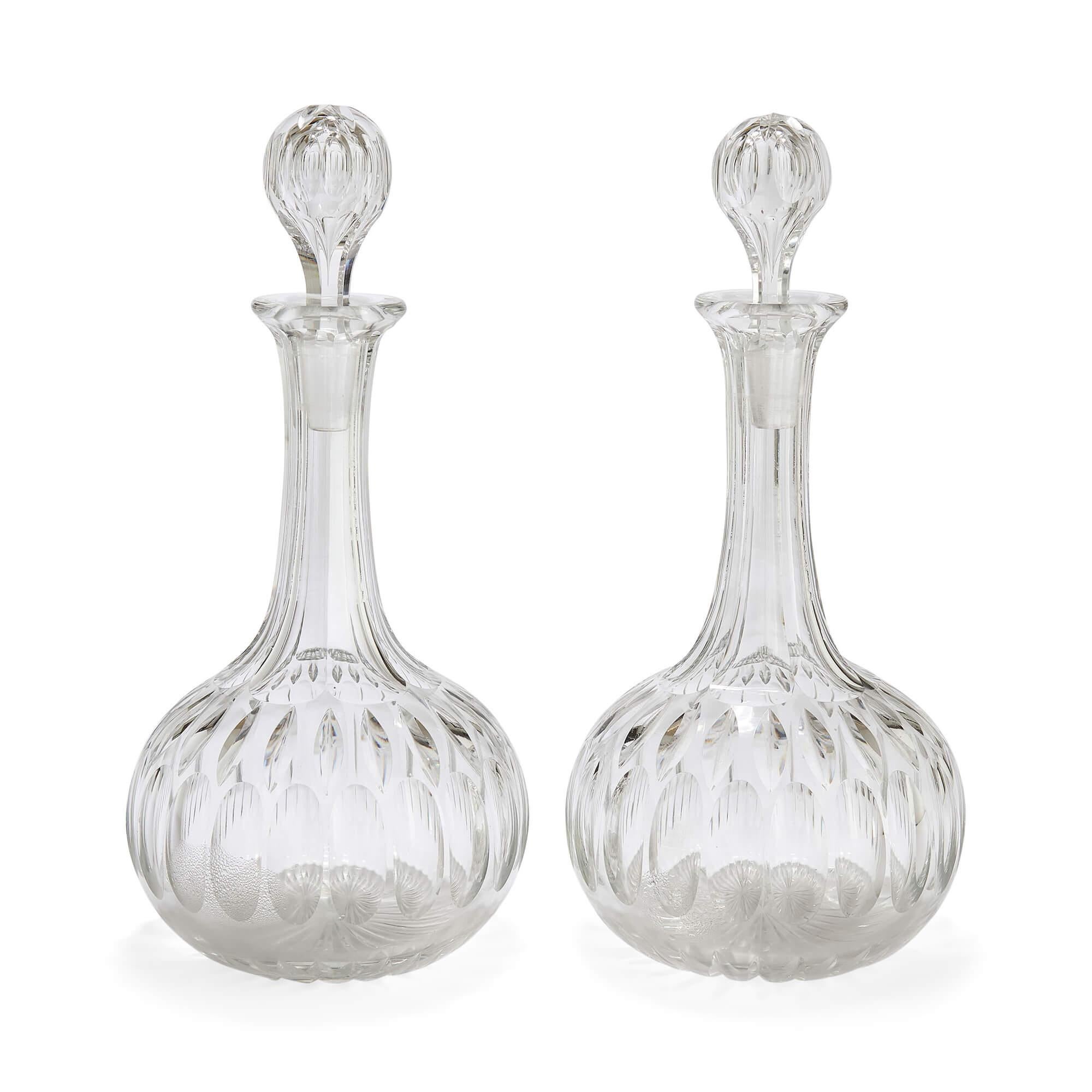 Two 20th century English glass decanters
English, 20th century
Height 30cm, diameter 14cm

A finely crafted pair of English decanters, each with a bulbous body tapering to a slender neck and finished with a flared rim. The bodies are richly
