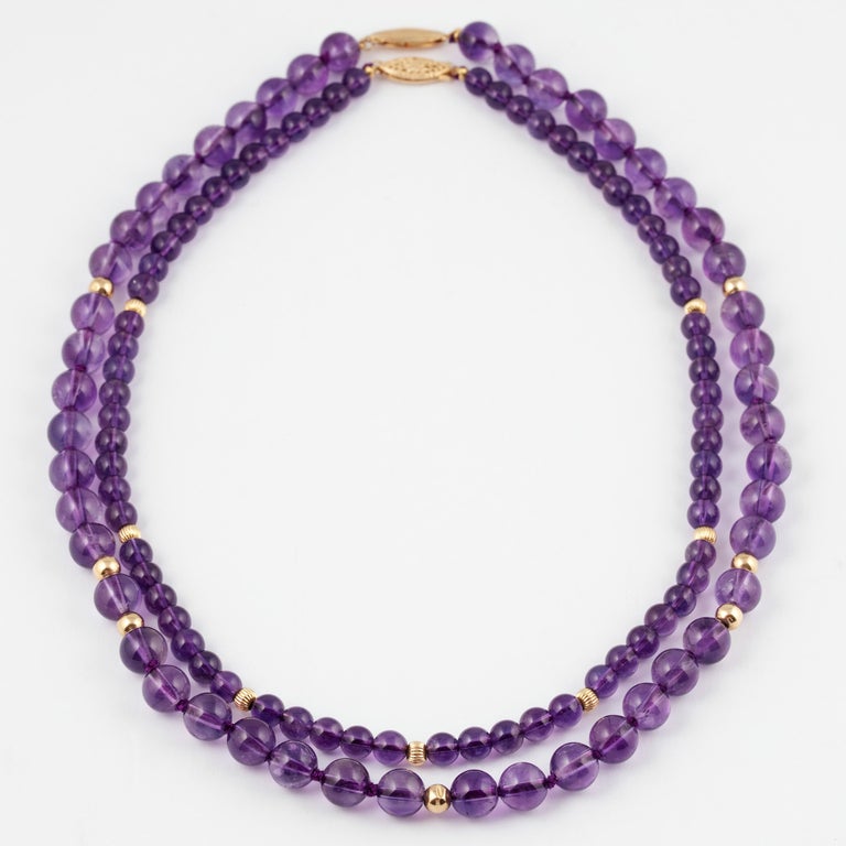 Two amethyst necklaces from the 1980s of deep violet color, one consisting of 48 8mm natural amethyst beads enhanced by 5 mm polished gold beads and a gold clasp; the other consisting of 68 6mm natural amethyst beads enhanced by 4 mm fluted gold