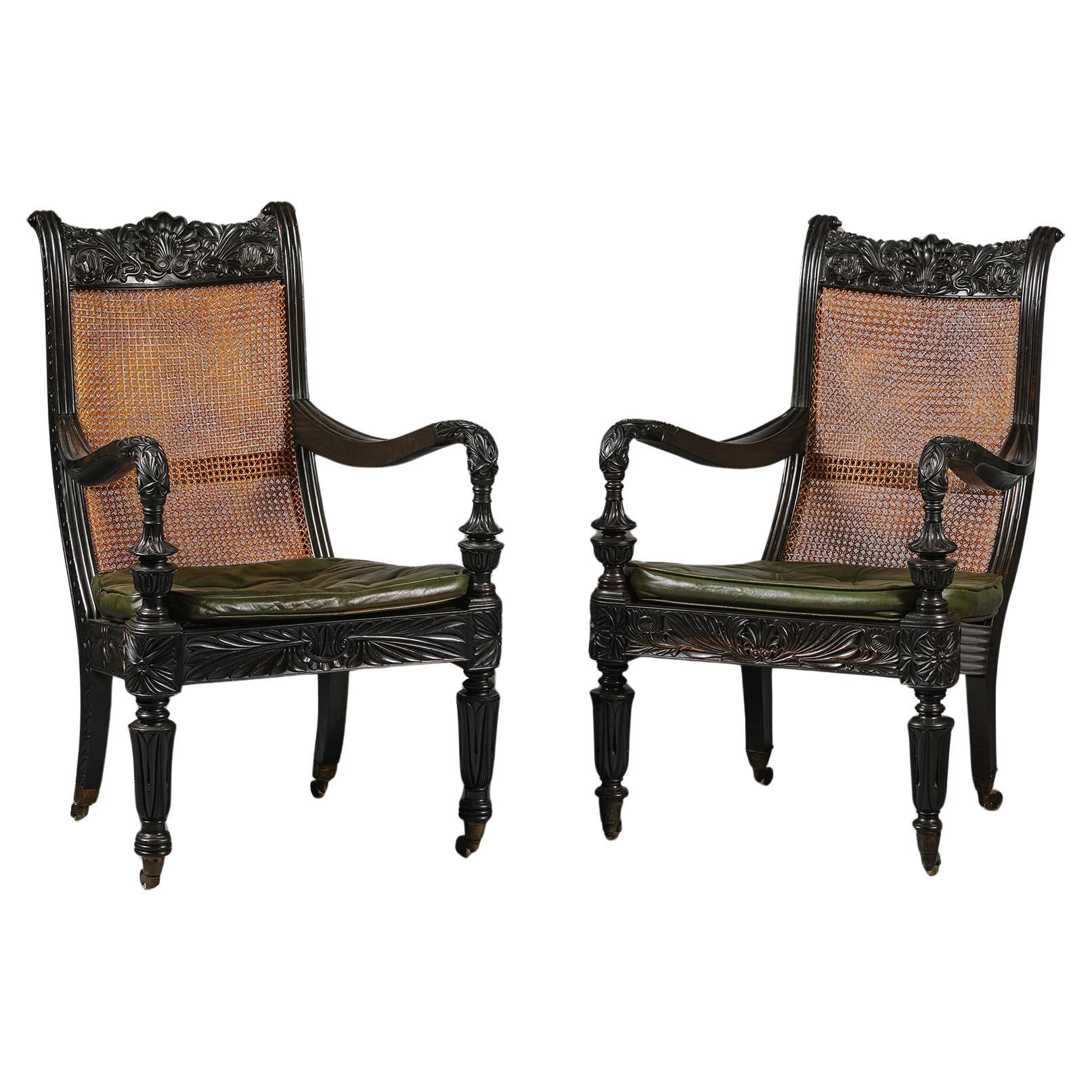 Deux fauteuils faciles en ébène sculpté anglo-indien