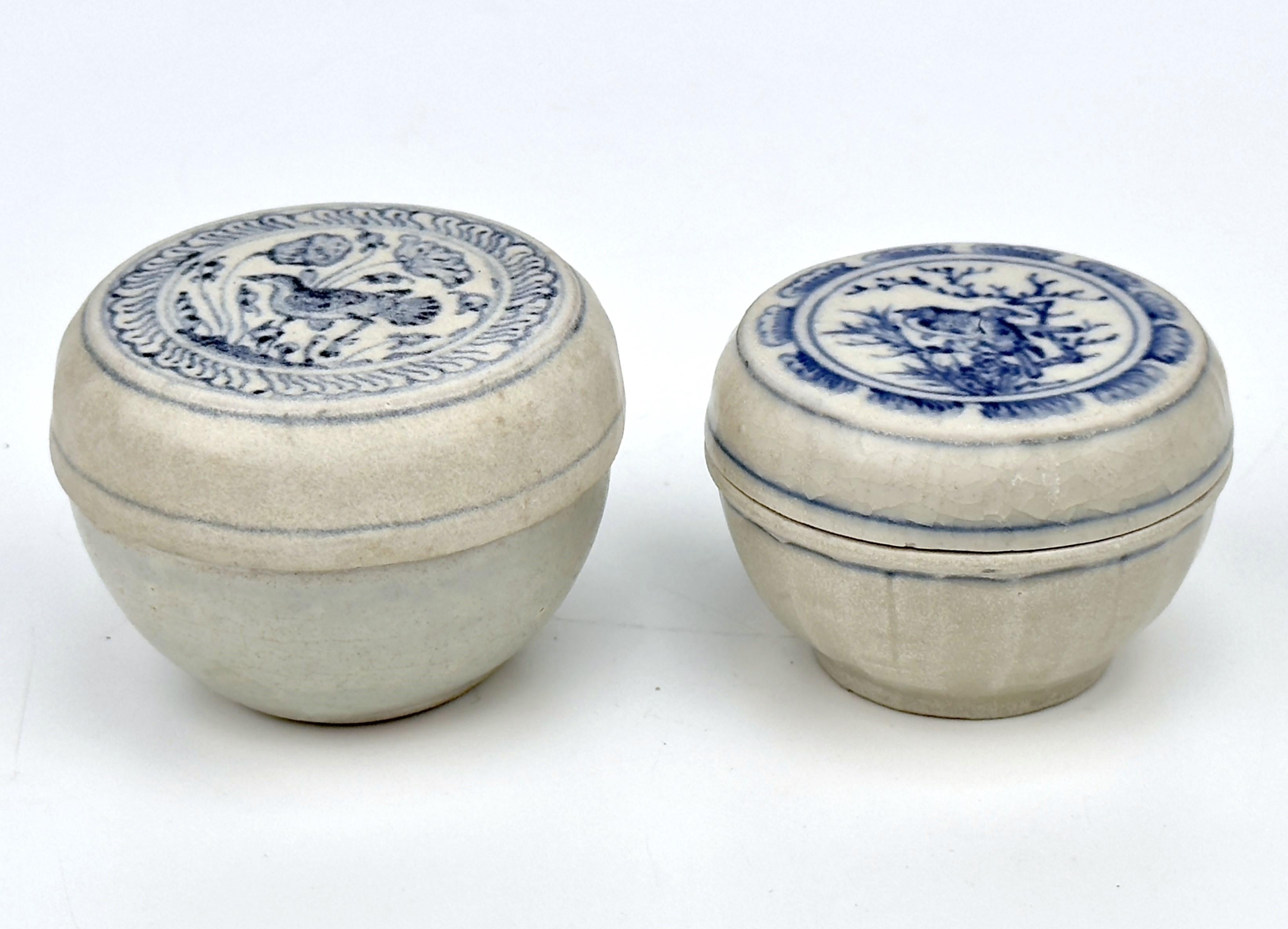 Vietnamese covered boxes with representative bird and plant designs. Both are made of cream-colored base and blue designs, typical of Annamese pottery. These shared characteristics highlight the traditional craftsmanship and aesthetic values of the