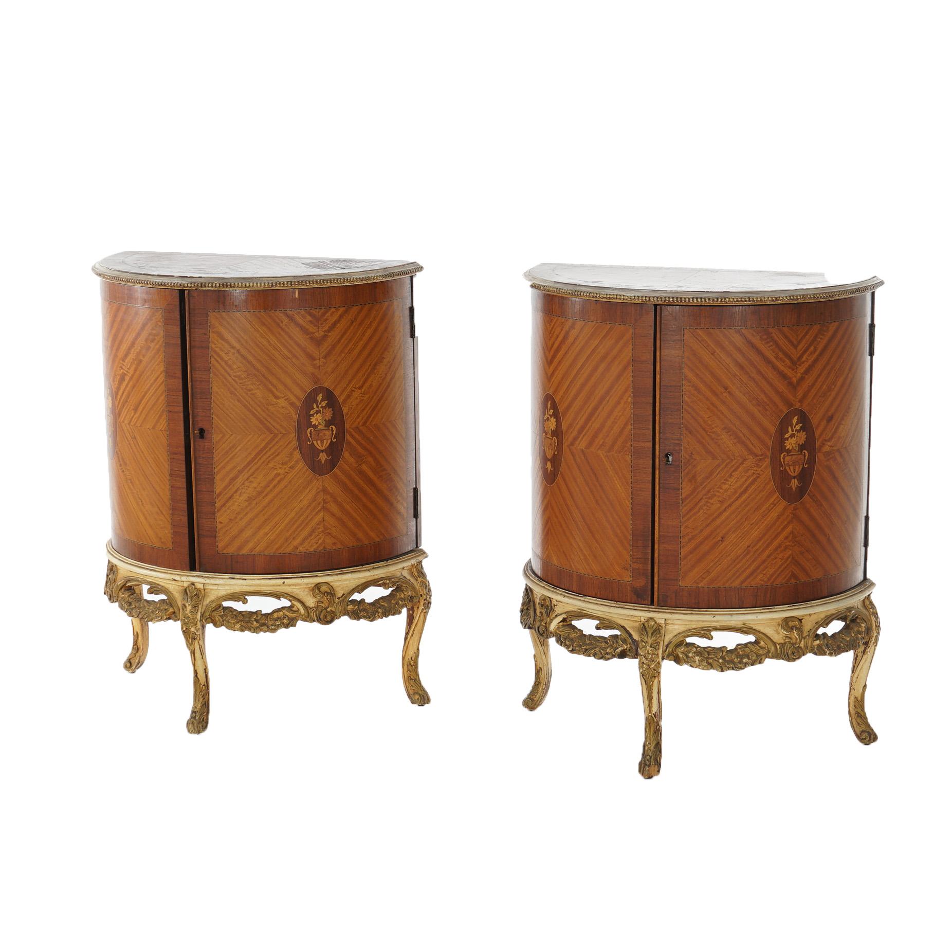 An antique pair of French side stands offers demilune form with satinwood facing and having floral marquetry medallion, double curved doors opening to shelved interiors, garland form apron and raised on cabriole legs, c1920

Measure - 29