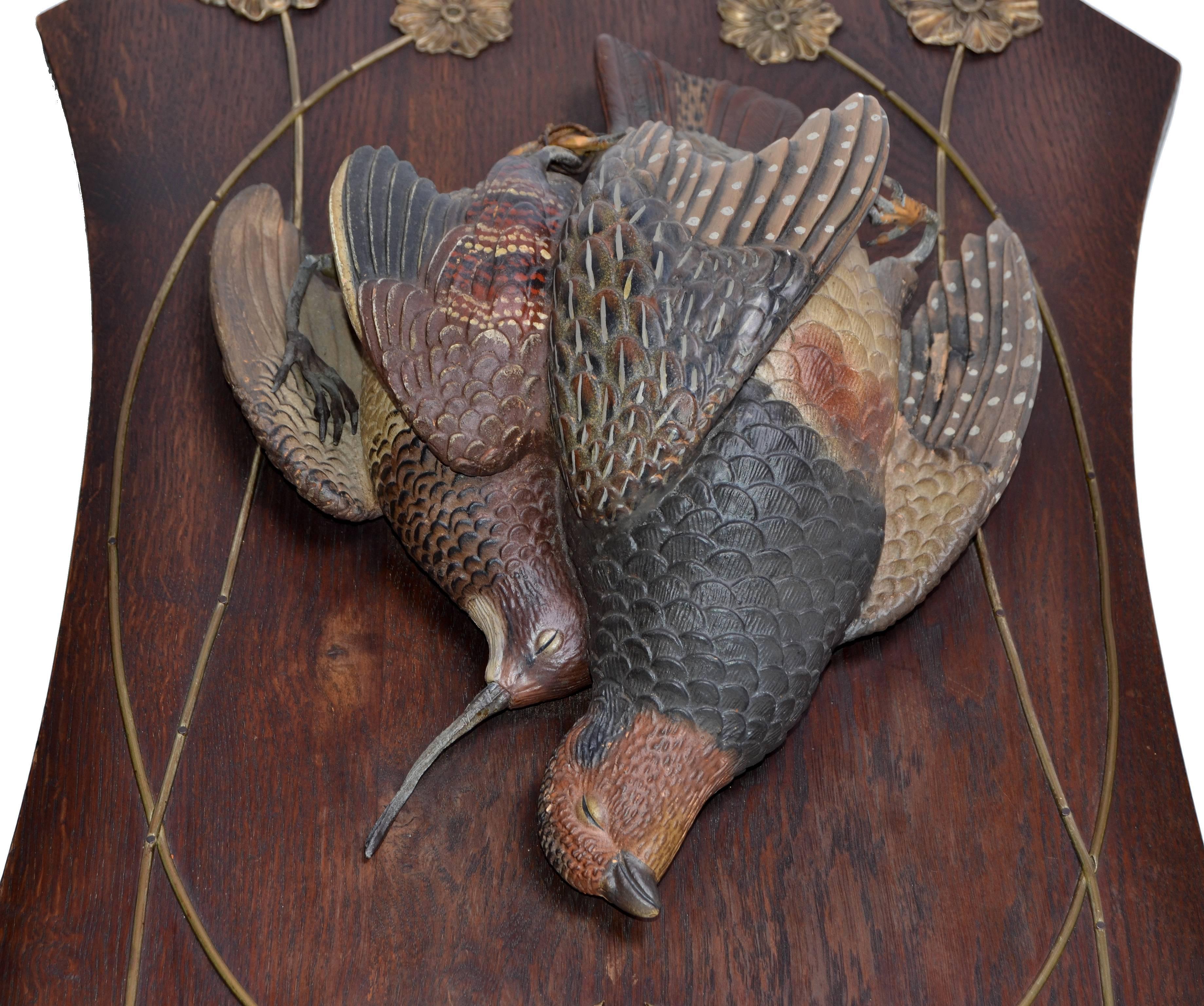 A pair of striking black forest Terracotta handmade Pheasant Birds mounted on a solid oak plaque with brass flowers and brass details.
These Animal Sculptures, Fine Art Pheasants are handmade out of Terracotta and hand painted. 
Secure Hanging