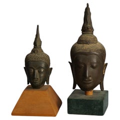 Deux têtes de Bouddha tibétains anciennes montées sur bronze coulé  XVIIIe siècle