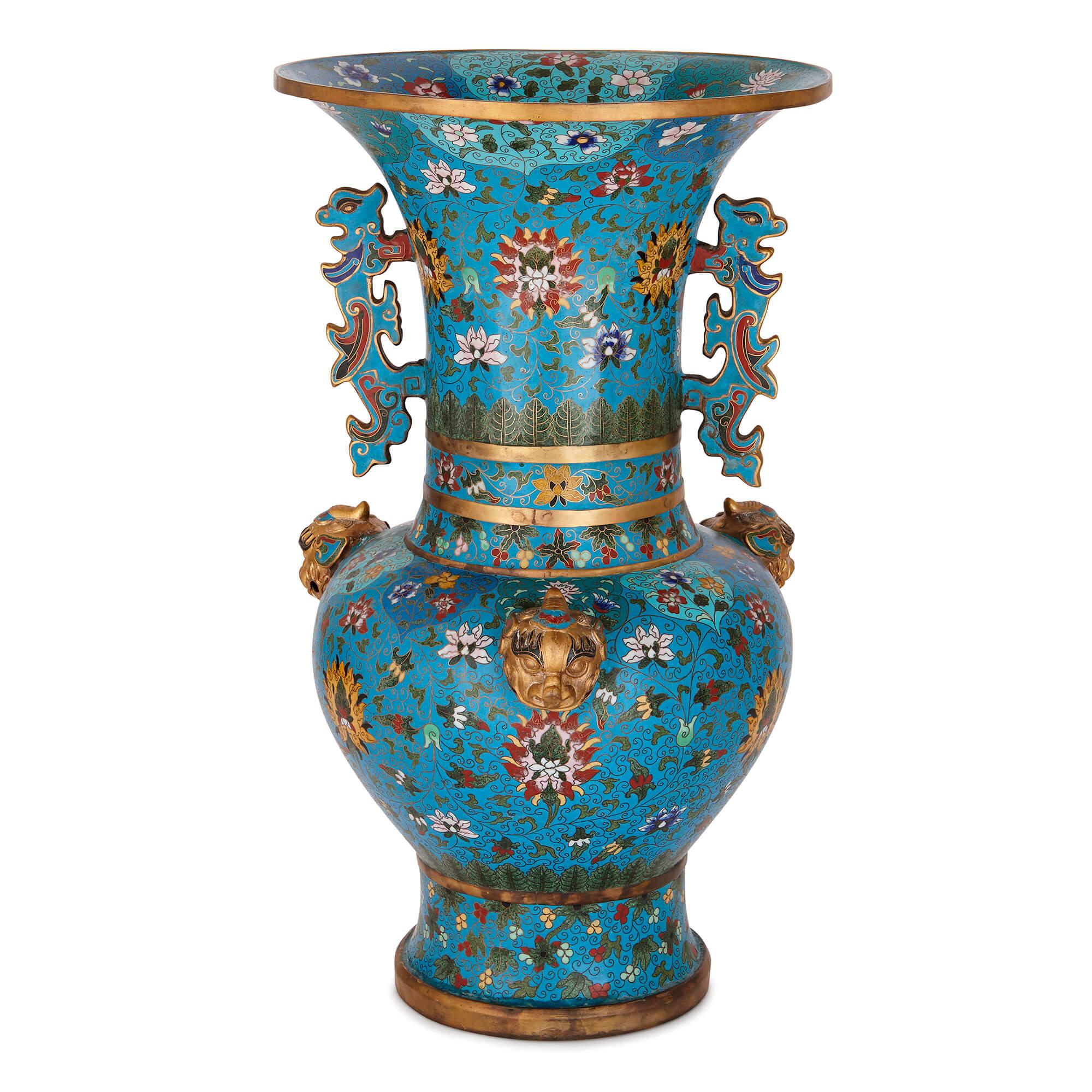 Crafted in the Qing dynasty, these vases are of elegant baluster form with broad, trumpet necks. The rims, necks and bases are decorated with gilt banding, which complements the gold lotus flowers seen on the bodies of the vases. 

These striking