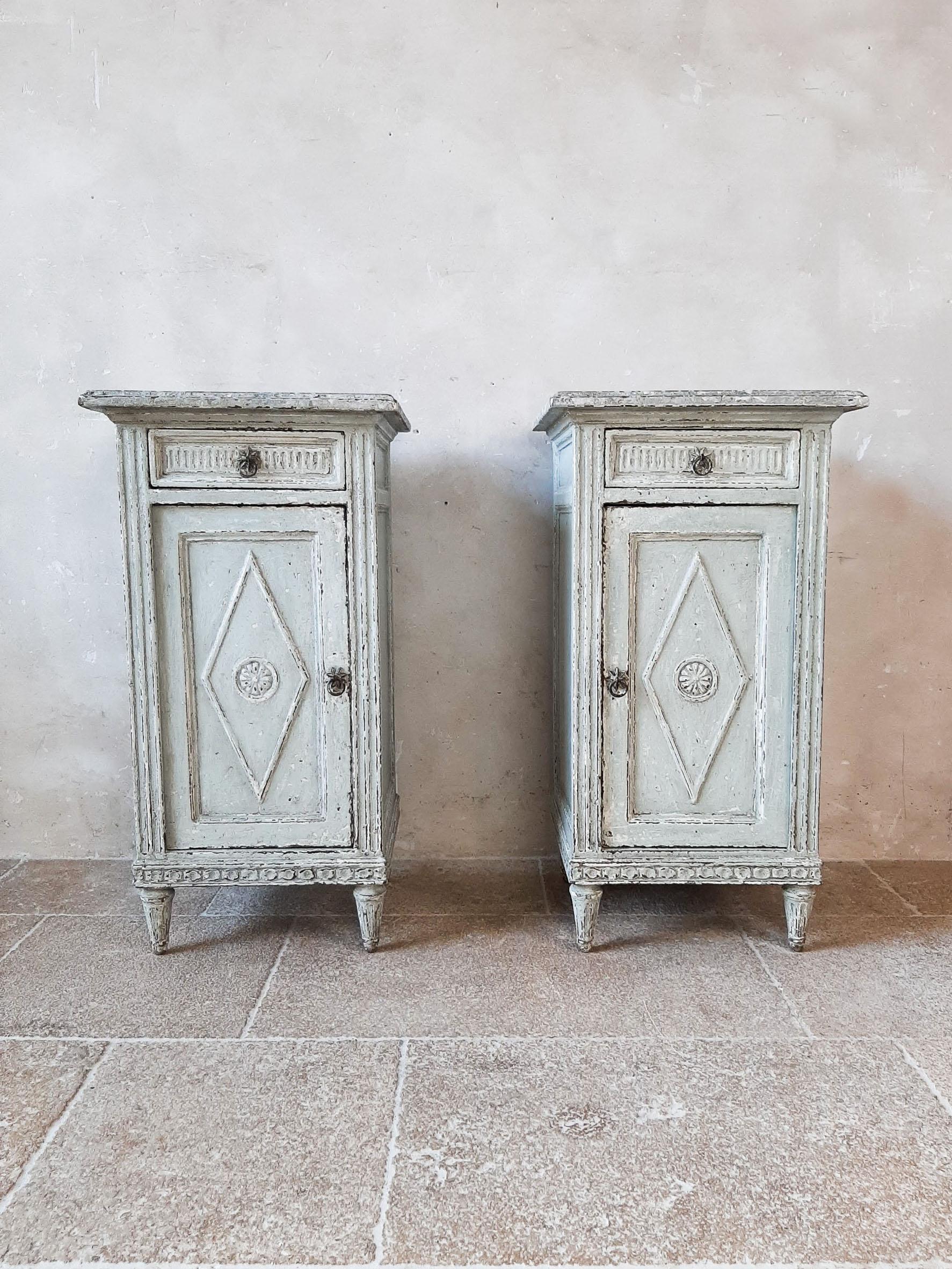 Set of two antique Directoir cabinets or nightstands from the 19th century. These stunning French cupboards or bedside tables made of oak / beechwood are finished in a beautiful aged gray patina with a marble look top.

Measurements: H 81 x W 43 x