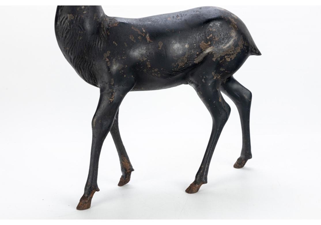 Two iron deer sculptures in original condition including a Stag and Doe. In a Black patinated finish, the Stag stands at alert while the Doe is in grazing form. Unmarked. With good weight and appropriate weathering. 
Dimensions: 
Stag - 23 1/4