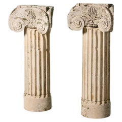 Deux piédestaux anciens à colonne ionique en pierre calcaire