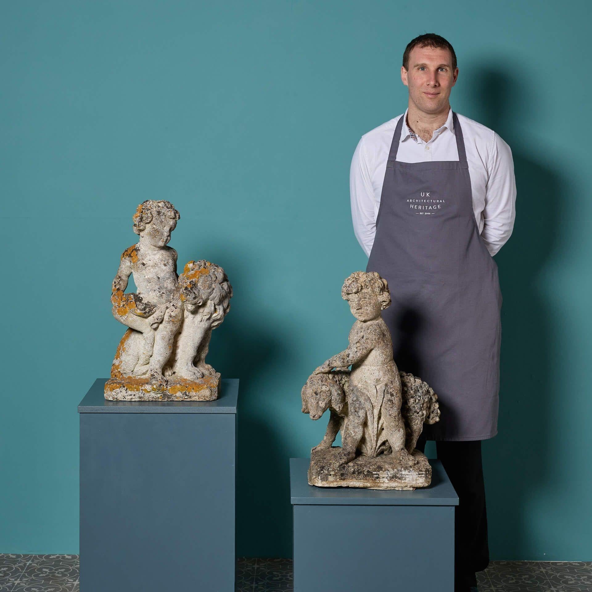 A pair of beautifully weathered antique Italian limestone ornaments of putti with a lion and a sheep; two of five we are selling in a similar style. Though these garden statues date from the early 20th century, they will make stunning sculptures in