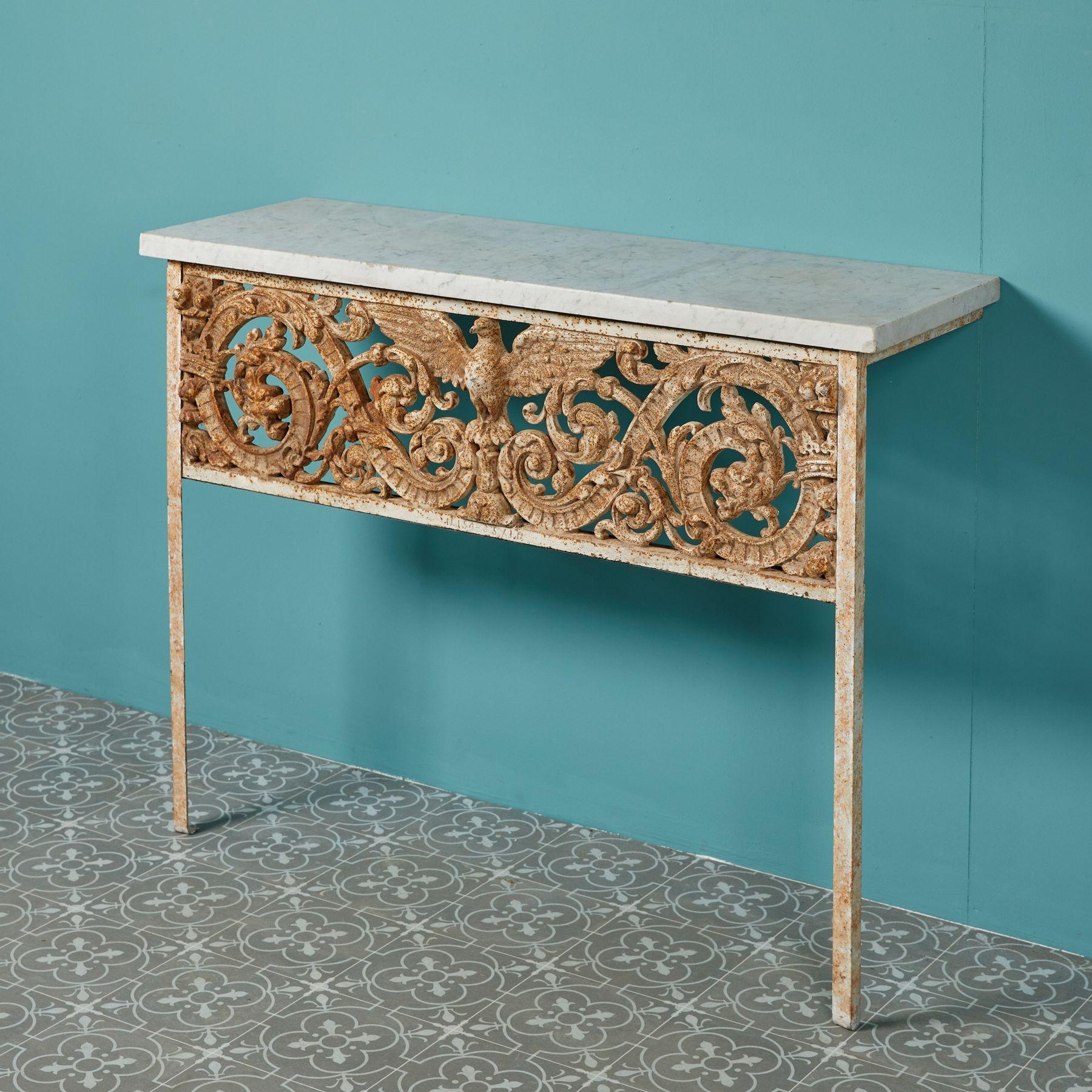 A highly decorative pair of antique console tables. Ornately decorated with stylised dragons, crowns, foliage and swags, these tables blend modern components with classical styling, making them a handsome focal point in interiors traditional and
