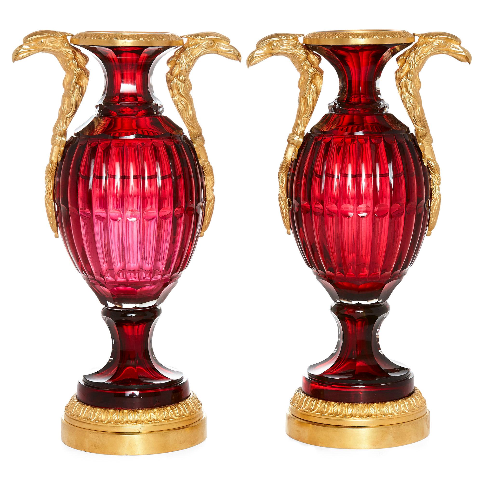 Two neoclassical style Russian cut glass and ormolu vases,
Russian, 20th century
Dimensions: Height 37cm, width 20cm, depth 13.5cm

Each vase has an ovoid ruby coloured cut glass body and a flared neck. They are mounted with twin ormolu handles,