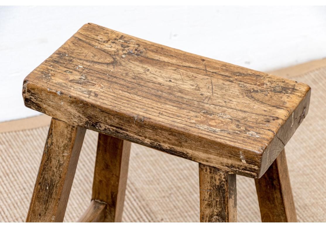 Two very well made Primitive hardwood stools with good graining and weight. . The stools have tight peg construction and an excellent time softened age patina with French polish. 

Dimensions:  Larger Stool 16”  wide (At base) by 7.35” deep by 20”